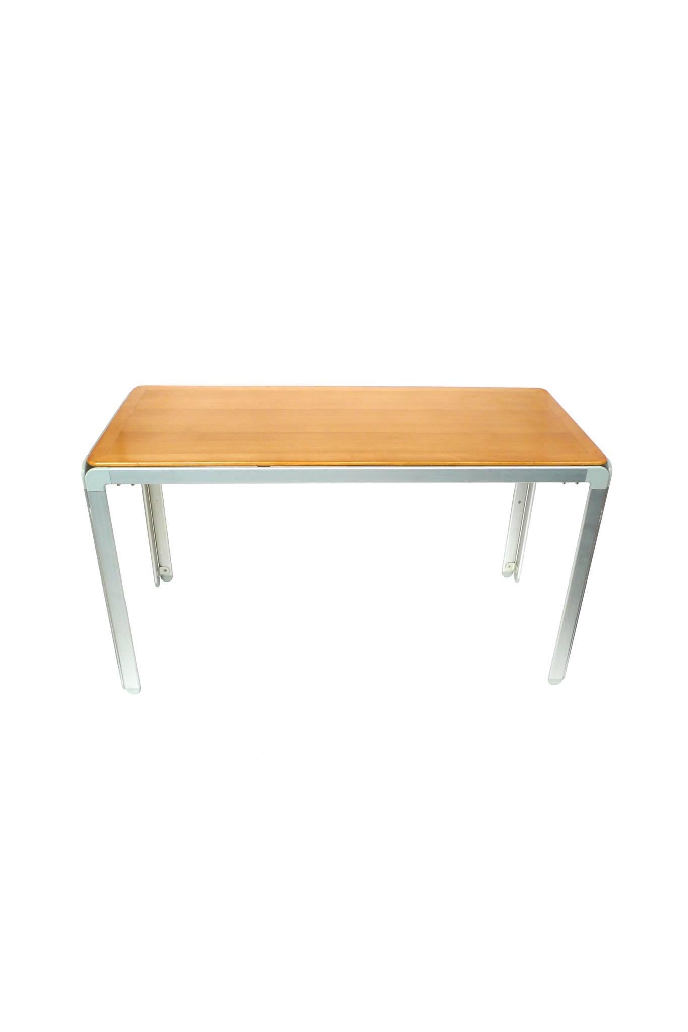 This table is designed by Danish architect Arne Jacobsen, renowned for his simple, light modern designs. The tabletop is beech wood with smooth bevelled edges, while the legs and frame are aluminium with rounded curves. This table is low with ample