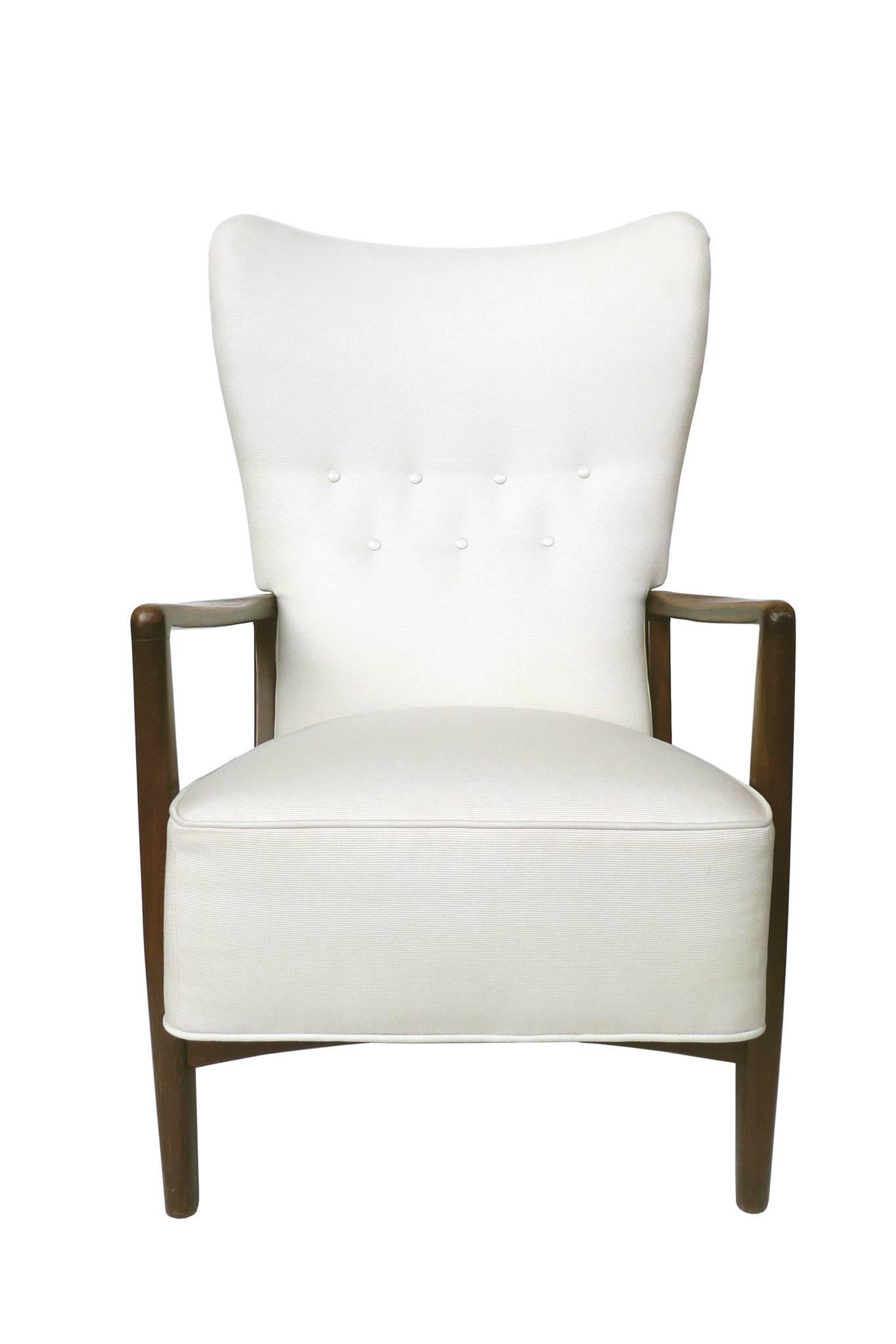 This beautiful 1940s set by Fritz Hansen is comprised of a settee and a wingback armchair, both button-tufted. They are newly reupholstered in an elegant white Duralee outdoor gabardine fabric. The hardwood arms and legs are in a dark walnut finish,