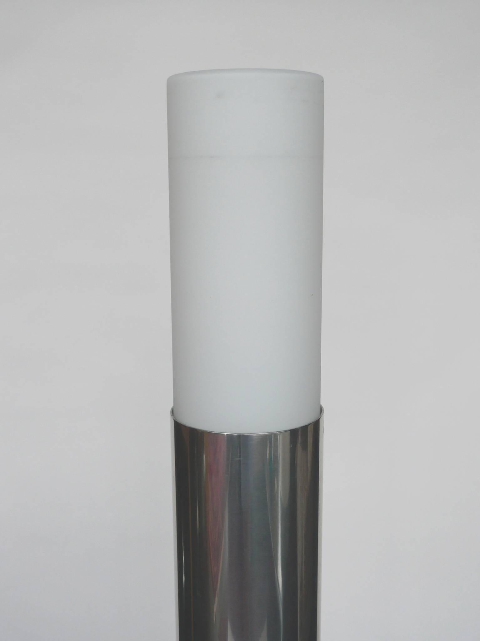 This Minimalist floor lamp is by designer and architect Paul Mayen. It consists of a removable milk glass head and a tubular aluminum body supported by a steel disc base in black lacquer. The lamp is touch sensitive. It can be adjusted from low to