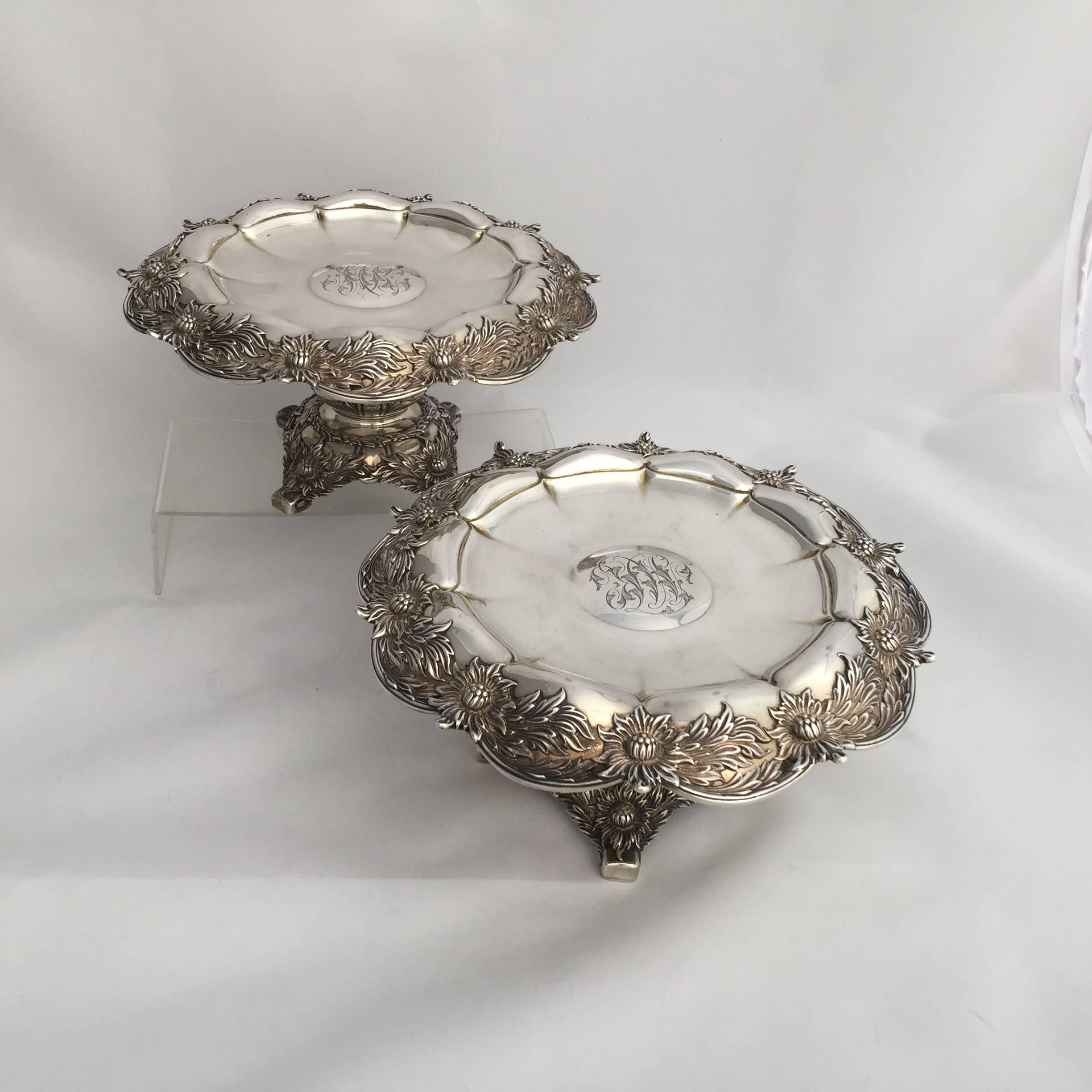 A pair of Tiffany sterling silver chrysanthemum tazzas.
The tops of the tazzas have scalloped rims with molded chrysanthemum borders. The stems of the pieces are bulbous decorated with acanthus, over a chrysanthemum molded base resting on four