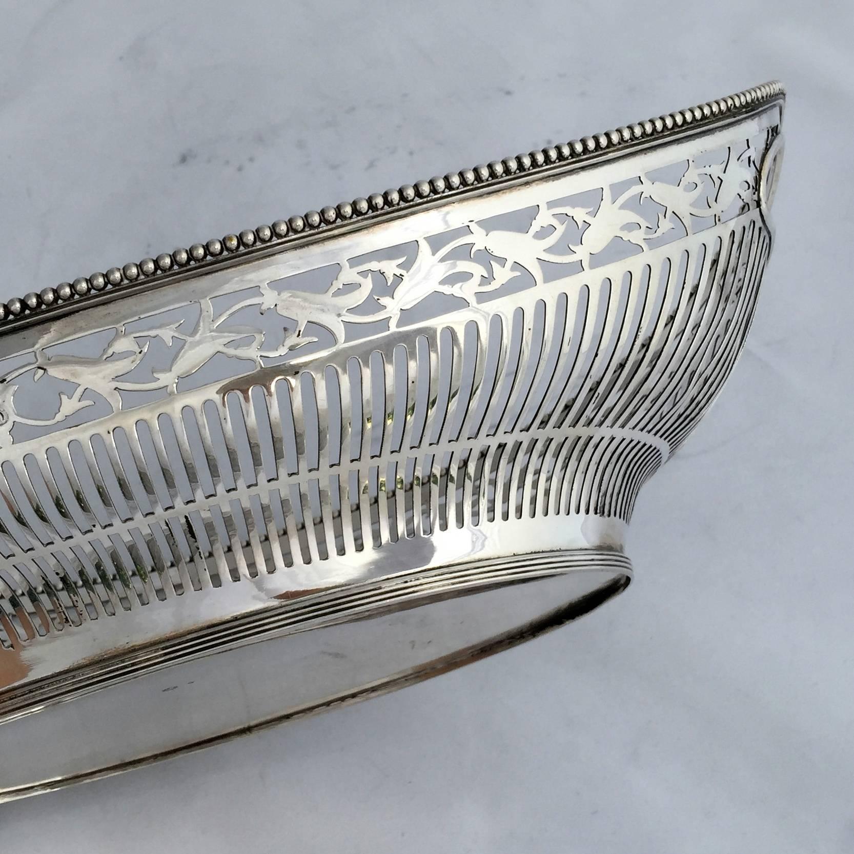 A large early 20th century Dutch sterling silver bread basket, note the one under the lion hallmark. The elegant oval curved shape is complimented by the fine pierced detail of the border and the pearl edge. Curved handles are set within the body of