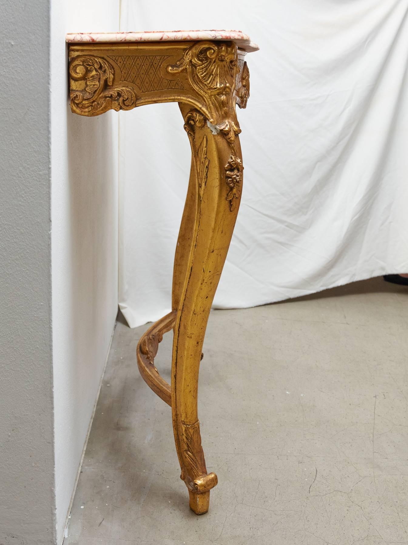 Late 19th century Belgian hall console with "rouge royal" marble top and polychromed wooden gold leaf undercarriage. This console comes from the hallway of a mansion in Brussels. It's a Louis XV style from 1880s. The marble piece balances