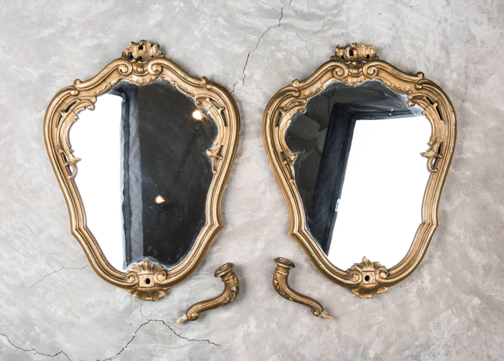 A dainty pair of gilt ended mirrors with removable candle holders. One mirror's glass is older than the other but both wooden frames are a pair and perfect for either side of a door way or fireplace.