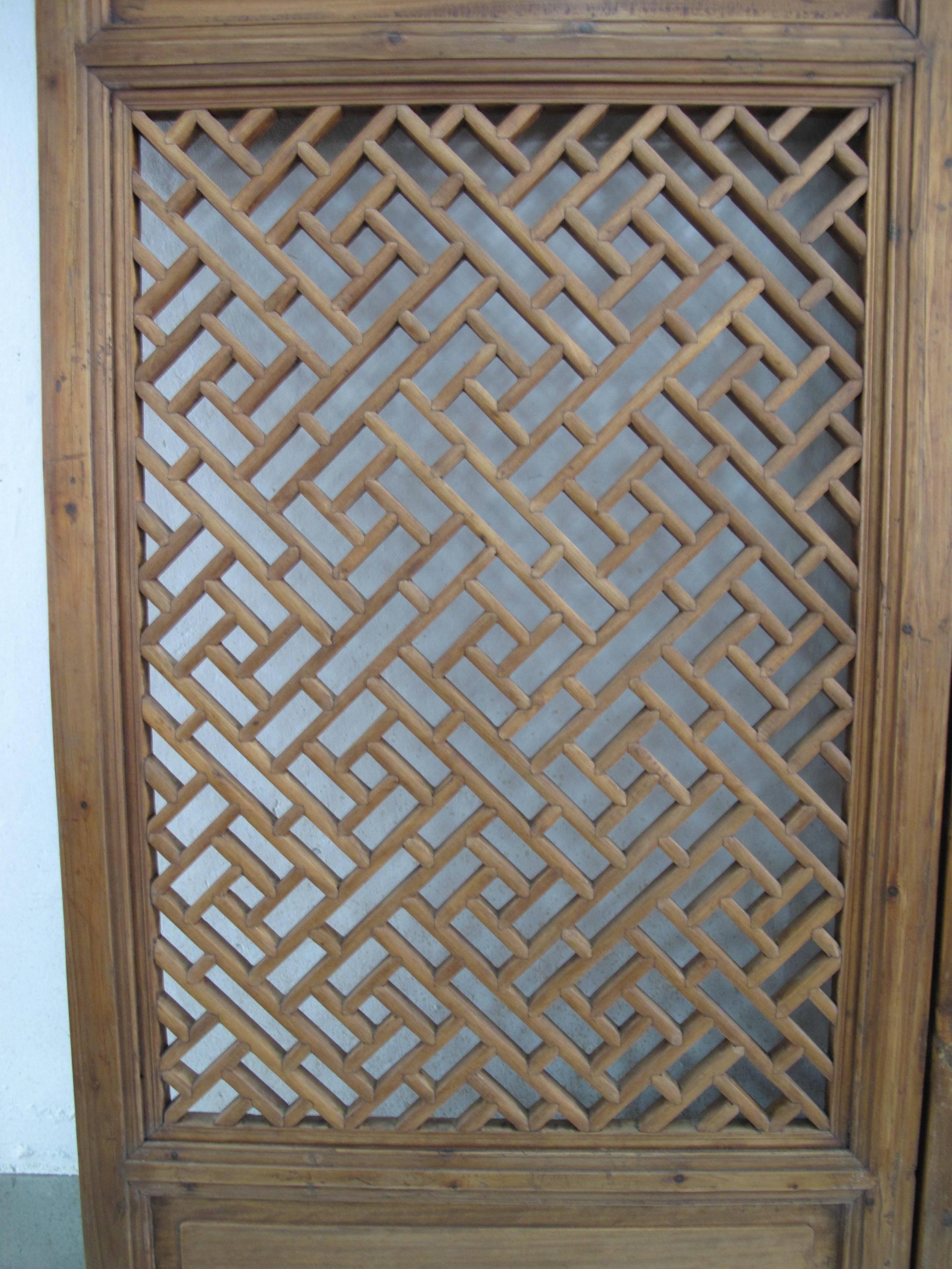 A pair of window screen with floral trailing plant motif on the top frame, and geometric lattice panel and bottom frame panel. Early 19th century, from Dongyang, Zhejiang Province. Camphor and fir wood.