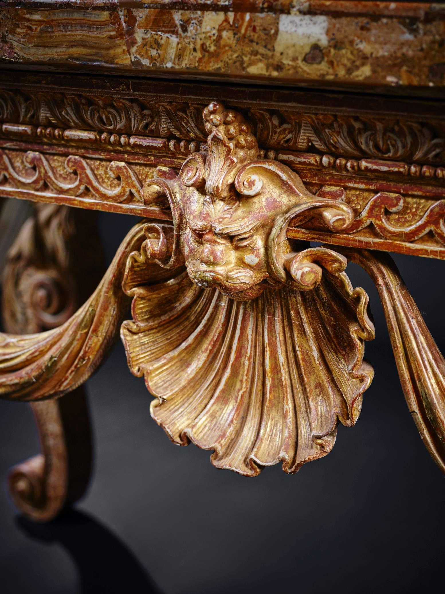 An important 18th century English George II carved pine and gilded side table, in the manner of Henry Flitcroft or William Kent. Having an earlier 18th or even 17th century Roman veneered alabastro fioretto top, re-sized to fit the base. The base
