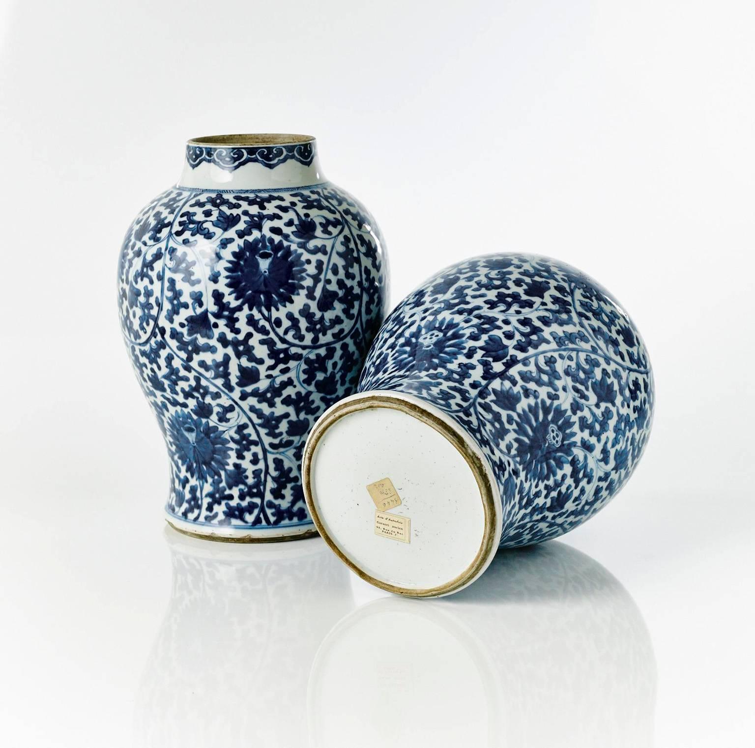 A good quality pair of Chinese Kangxi period blue and white porcelain jars, thrown in a baluster shape and with all-over underglaze blue decoration. The main body of the jars decorated with Lotus flowers and scrolling spandrels, the necks with a