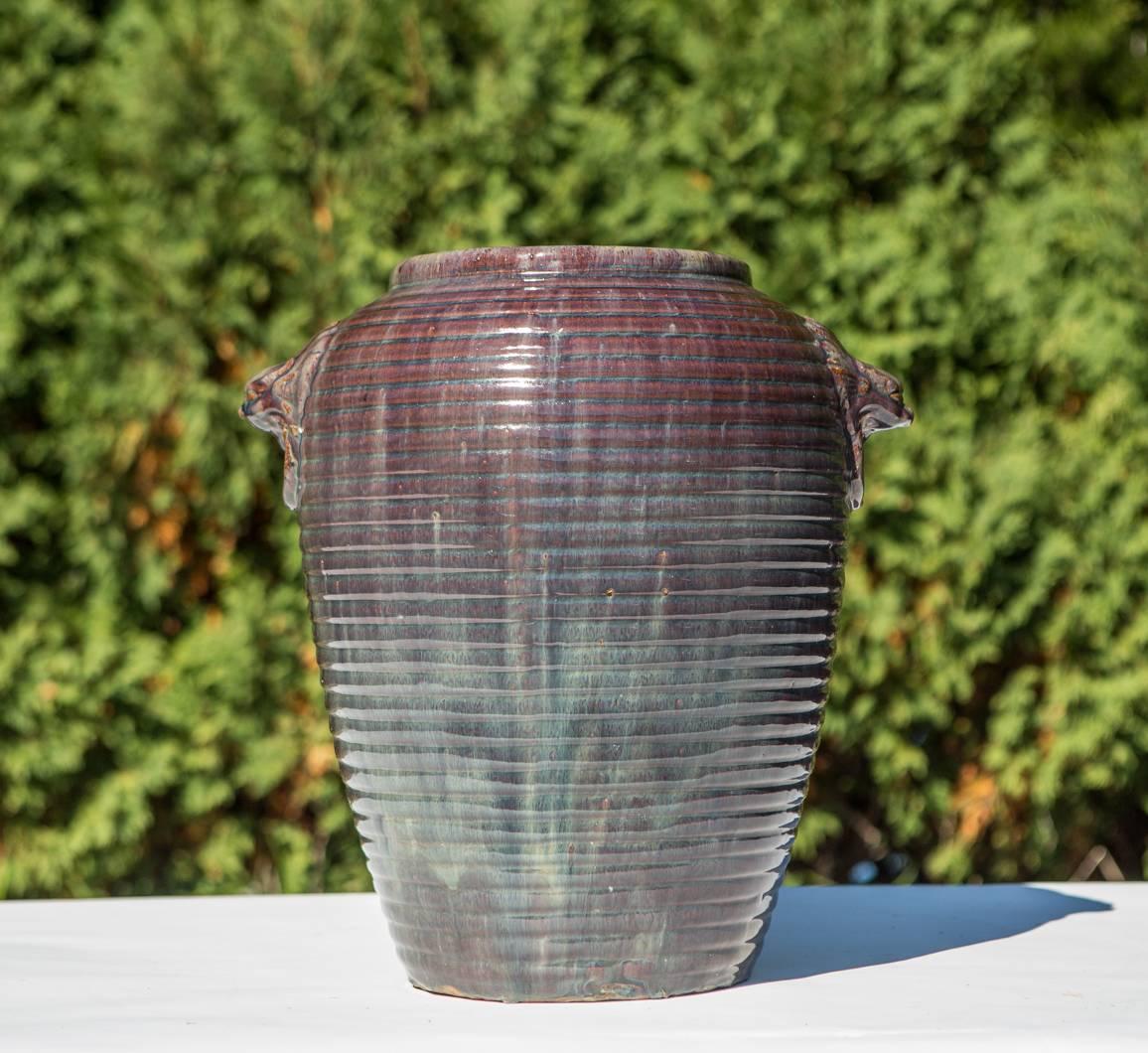 Late Qing dynasty vase. This lovely Chinese ceramic vase is made with a flambe drip glaze and adorned with lions' heads on either side.