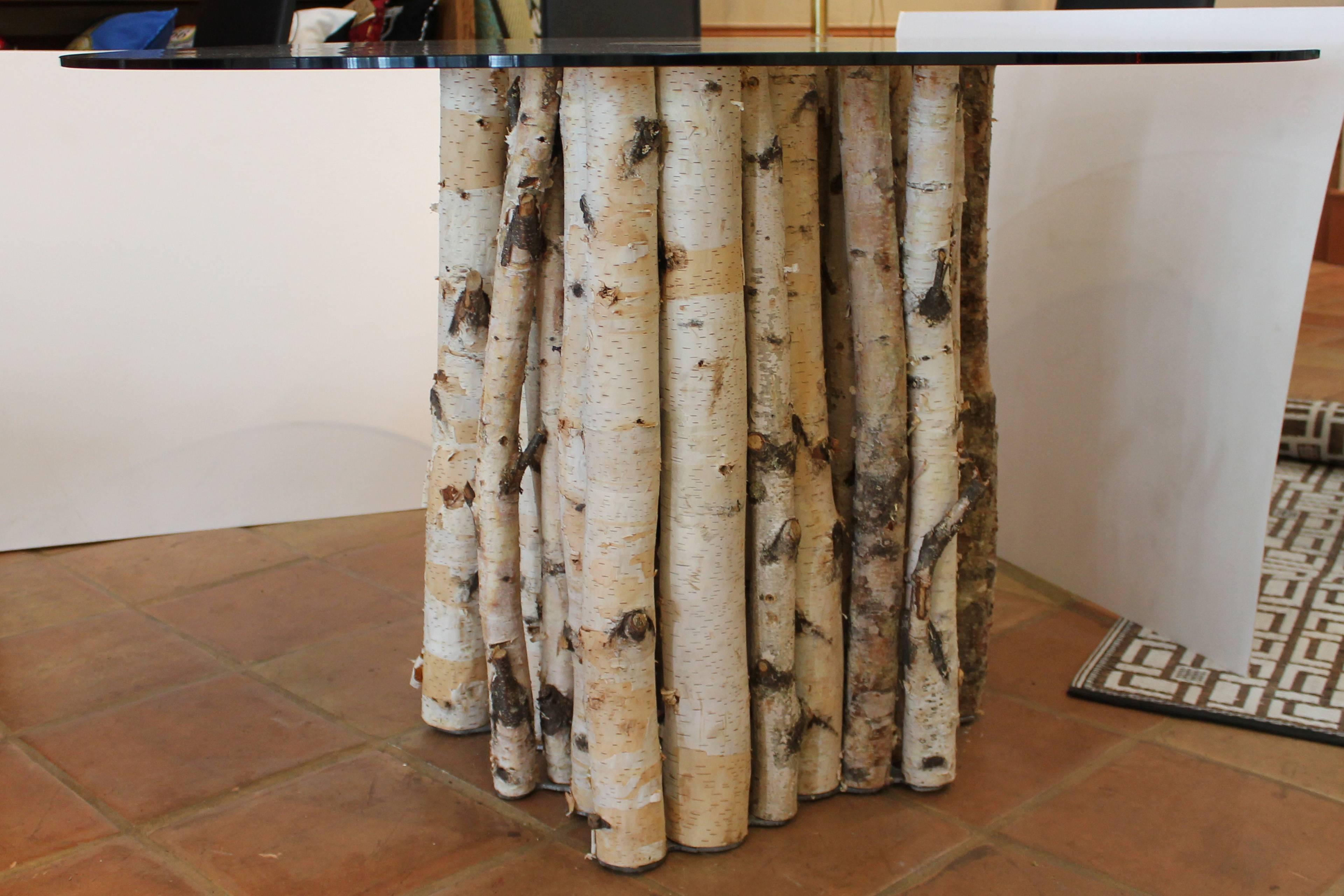 Authentic birch poles supported by a custom steel base- smoked tempered 1/4”glass. 

Custom piece by Reclamation.
 