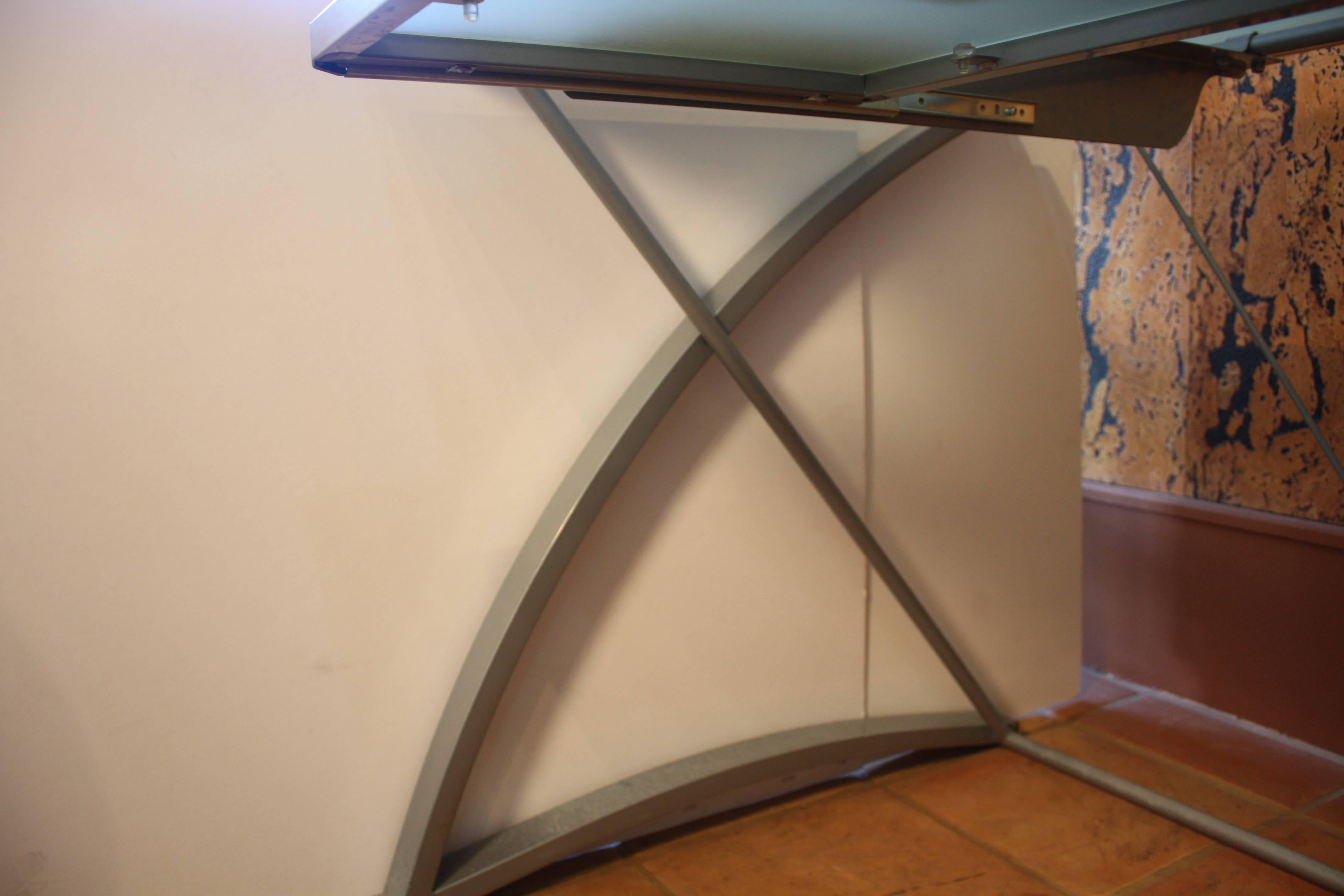 This sleek contemporary designed glass and metal desk features a keyboard pull out and opaque tempered glass. Length 52” by 30” in width and stands 31” high. Metal legs have slight finish imperfections- in good condition. From the company’s early to