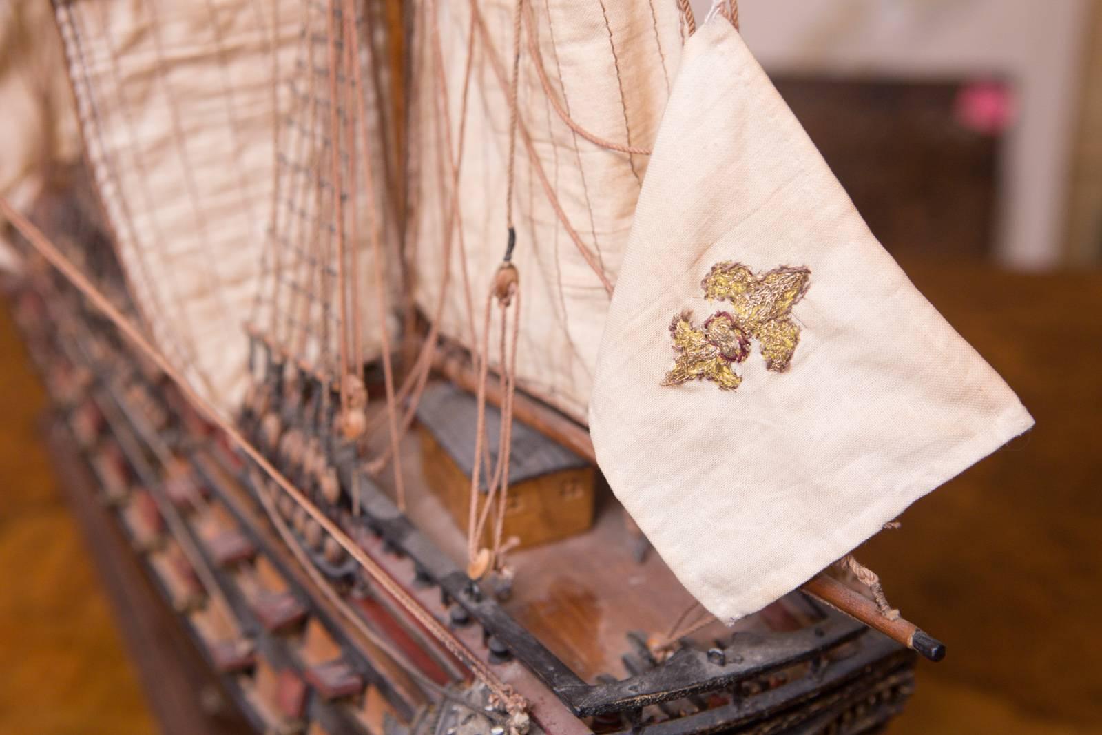 An antique model ship brought over from Paris in the mid-1990s. Absolutely stunning attention to detail with lovely gold fleur-de-lis on the front sail.

All rigging, sails and other small details are entirely intact.

Measures: 36” W x 32” H x