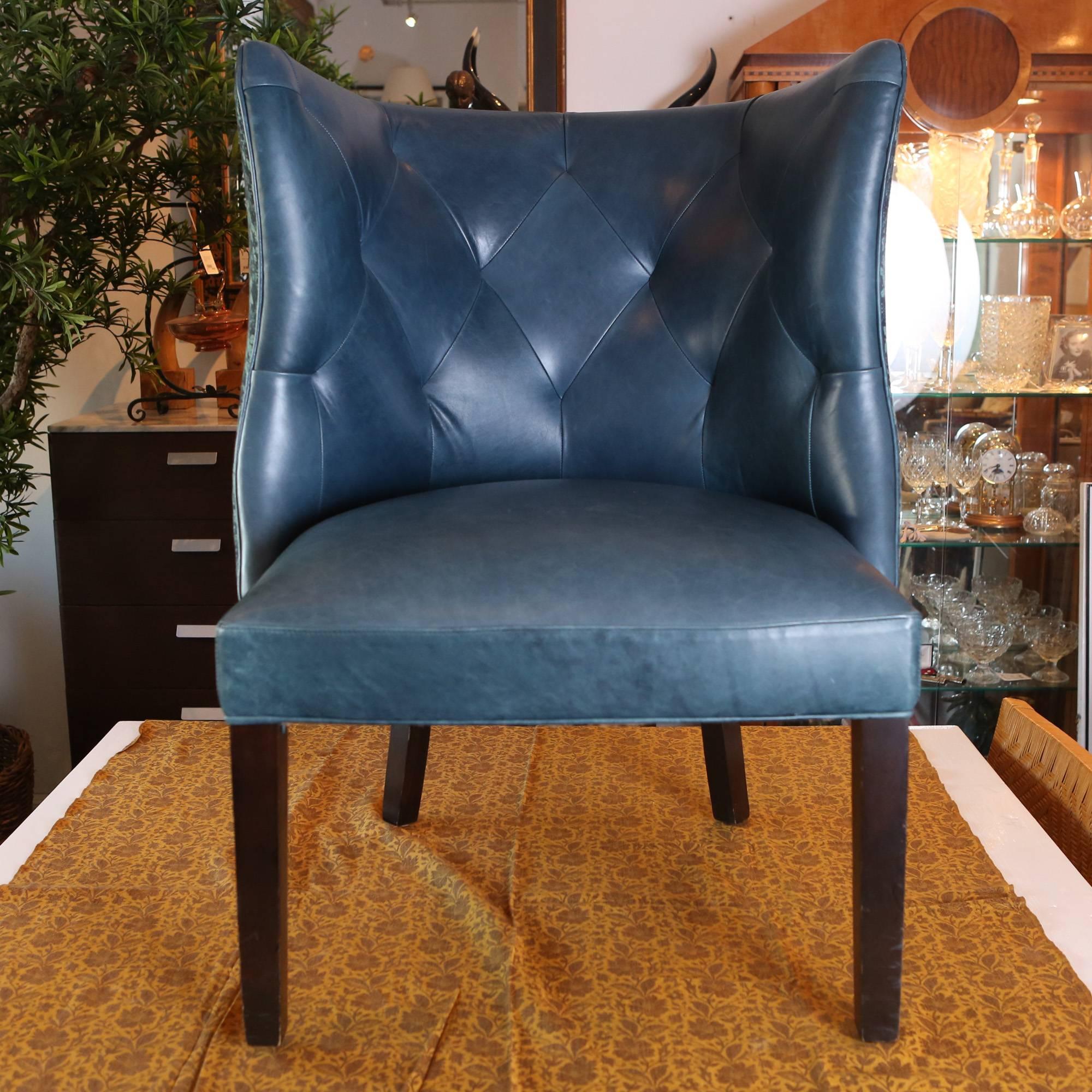 Blue tufted leather armchair with a Tibetan blanket backing on carved wooden legs. Assembled in the United States.