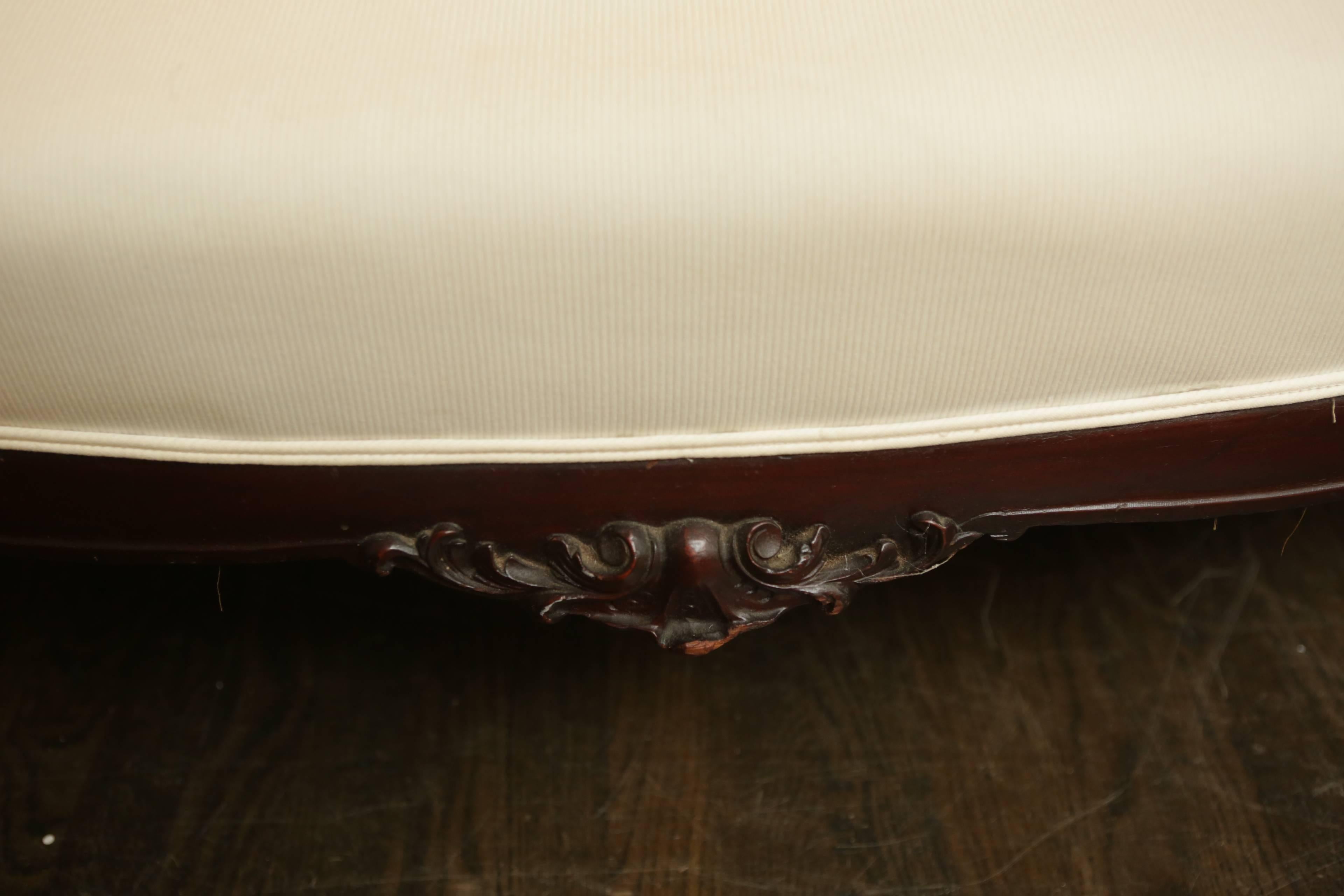 An elegant 19th century American carved mahogany settee in the French style. Newly covered in heavy cotton duct upholstery. The frame is very heavy and extremely sturdy.