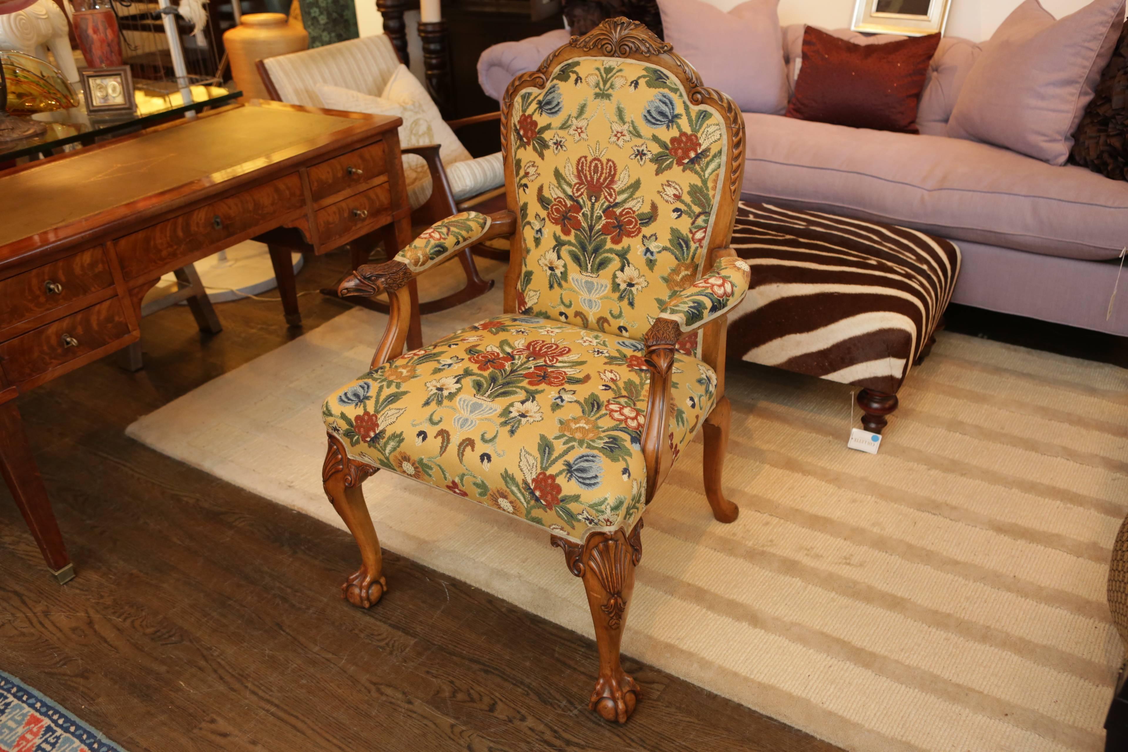 A unique and handsome 18th century styled hand-carved walnut armchair with floral tapestry-weave upholstery. Features carved eagle head arm rests with matching upholstery, and ball and clawed feet.