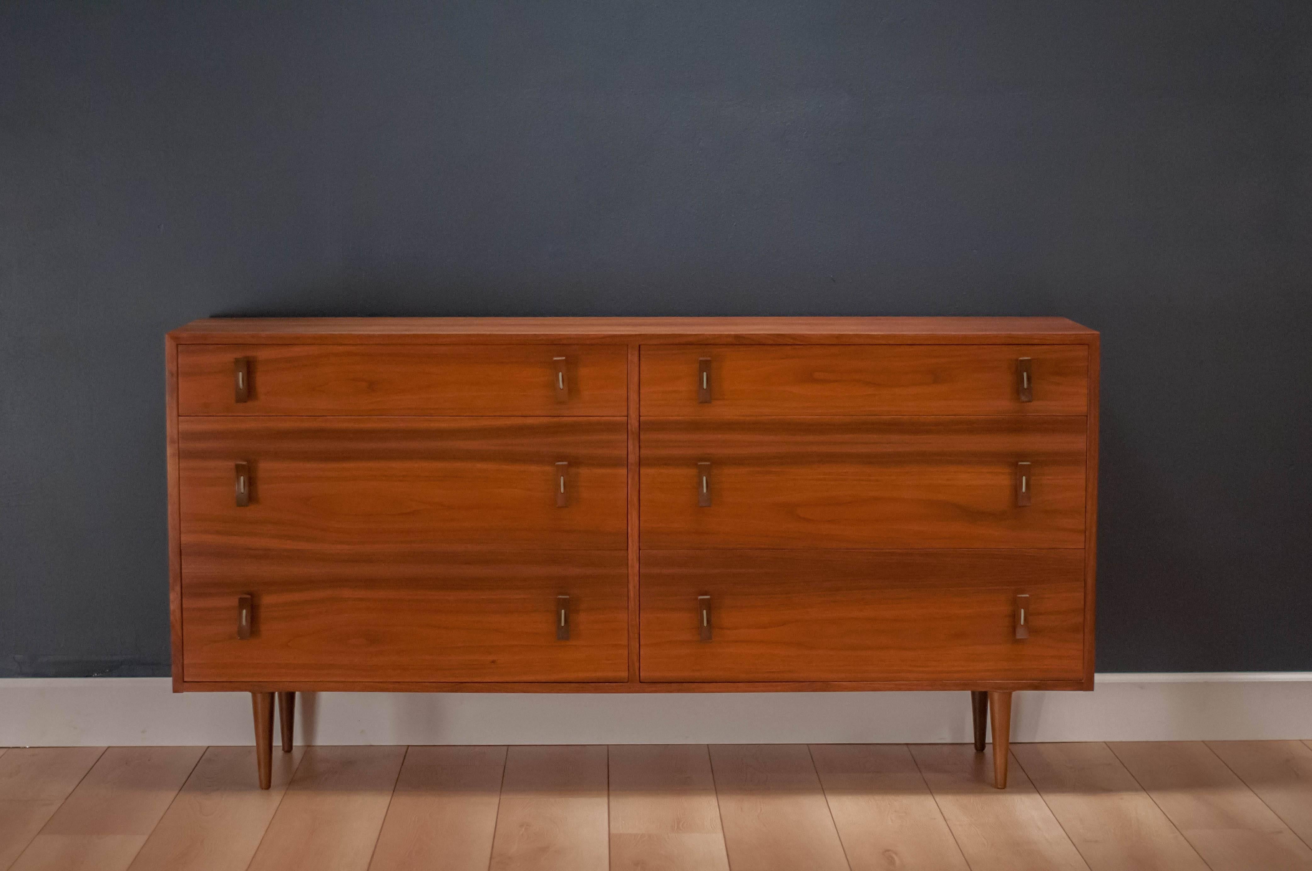 Mid-Century Modern Stanley Young dresser for Glenn of California in walnut. This piece features six drawers that provide ample storage space. Drawers are accessorized by the designer's signature walnut and bent metal pulls. Case piece displays