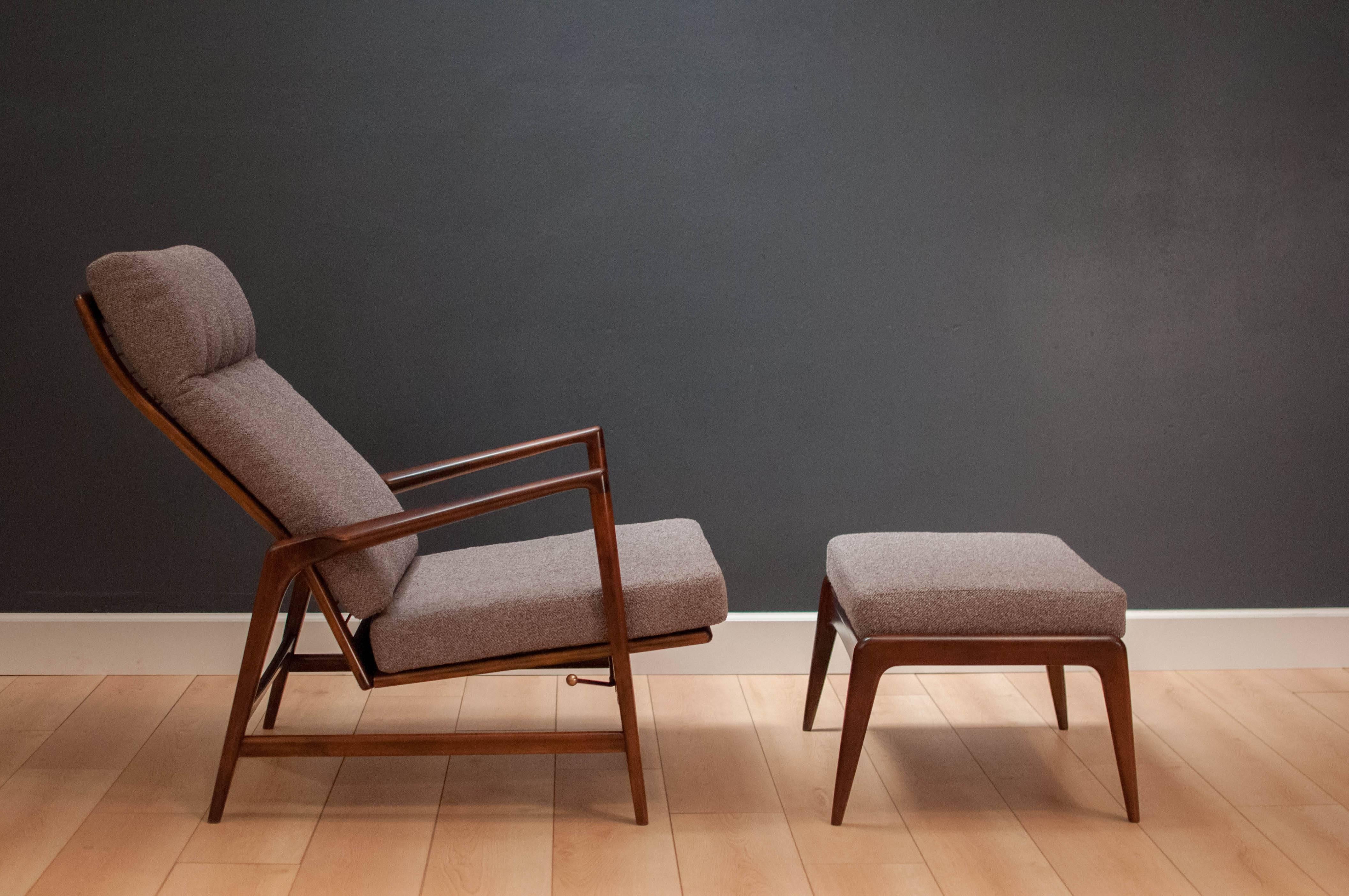 Danish modern reclining lounge chair and ottoman designed by Ib Kofod-Larsen. This piece has been newly reupholstered in a soft grey Maharam fabric. Frame displays sleek minimal lines with sculpted arms. 
 
Measures: Recliner: 29