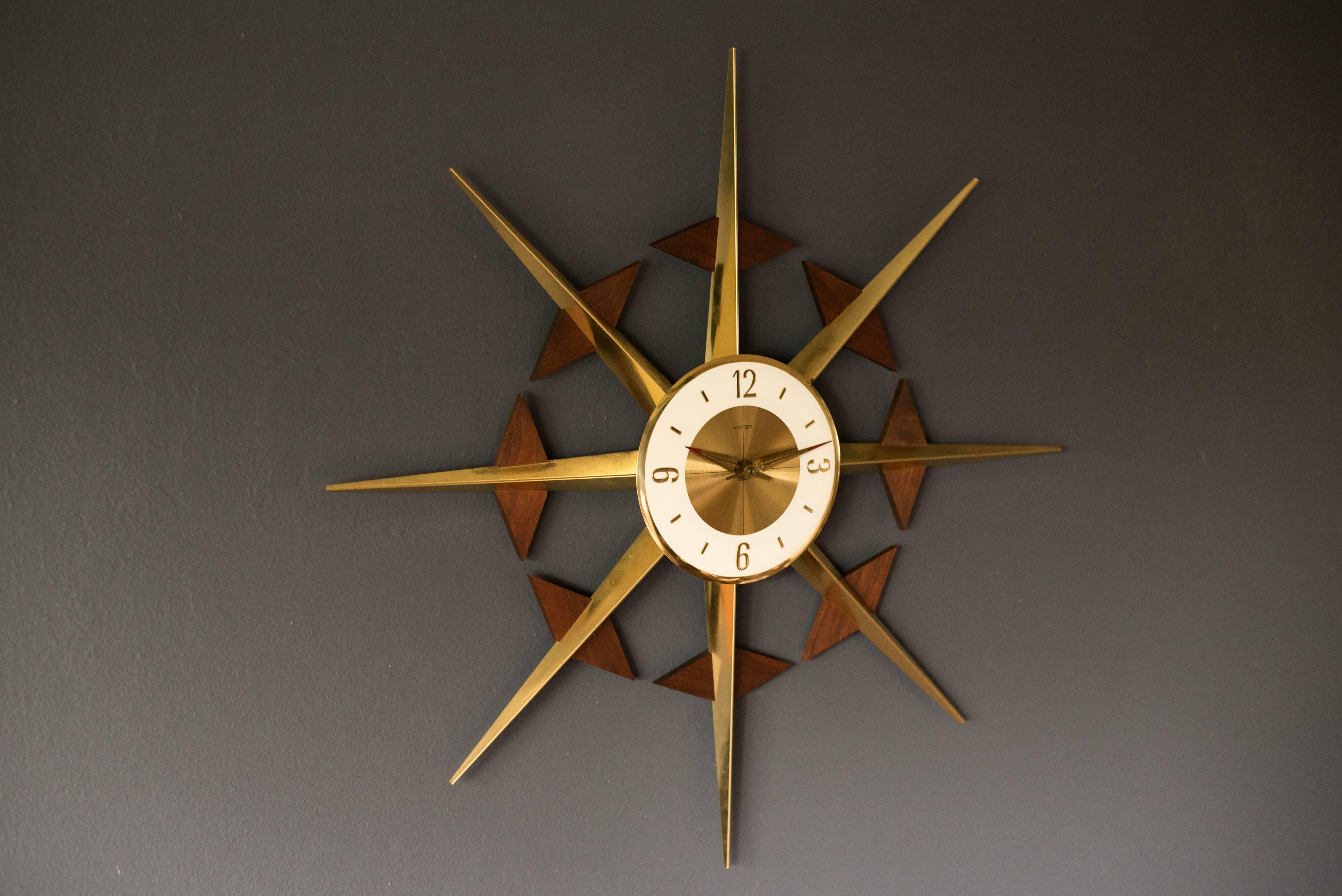 Mid-Century atomic starburst wall clock in walnut and brass. This piece includes original mechanism and looks great with any modern decor.

Dimensions: 25