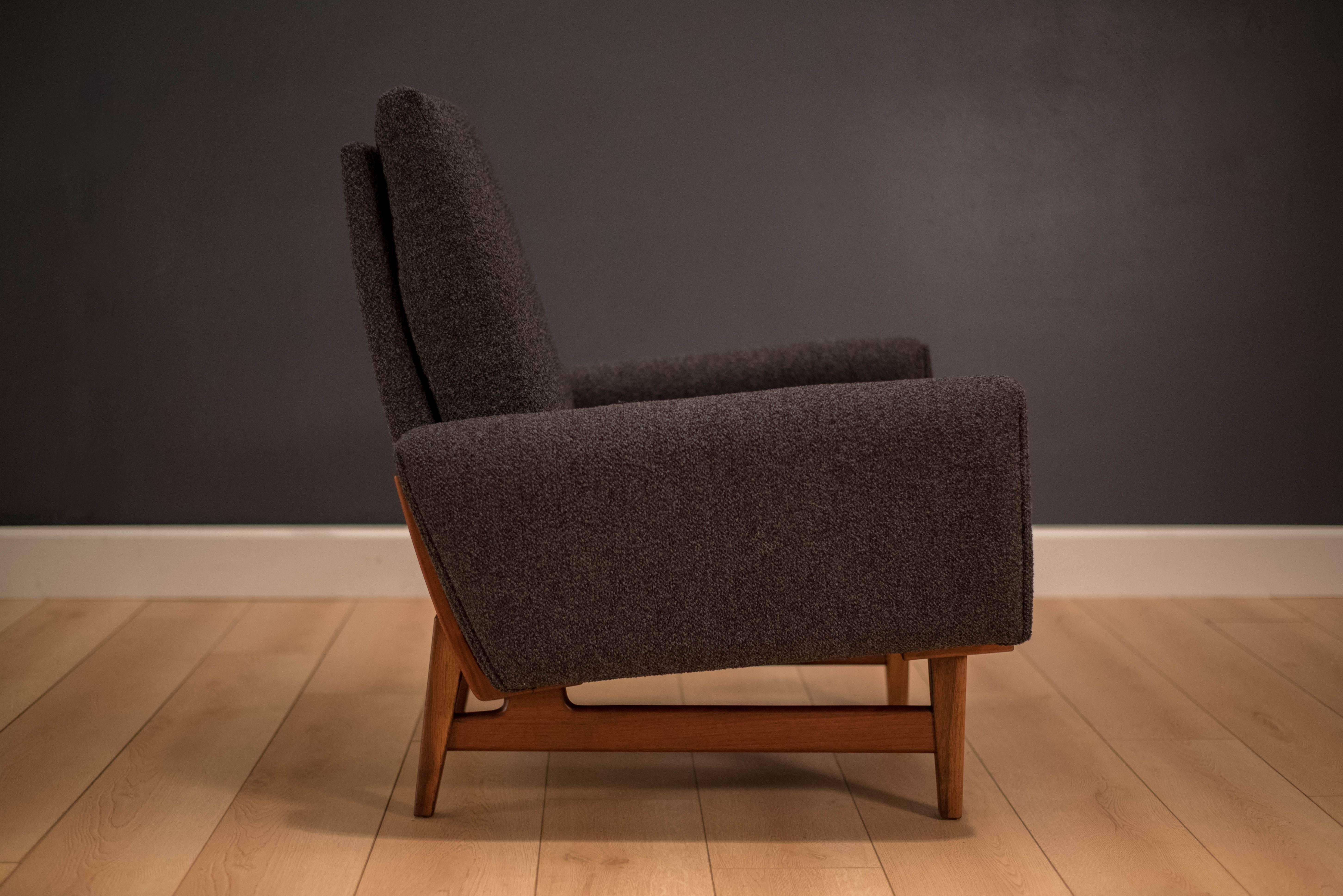 Mid-Century club chair designed by Jens Risom. This piece has a unique solid walnut frame and has been professionally reupholstered in charcoal grey Maharam Kvadrat. 

   