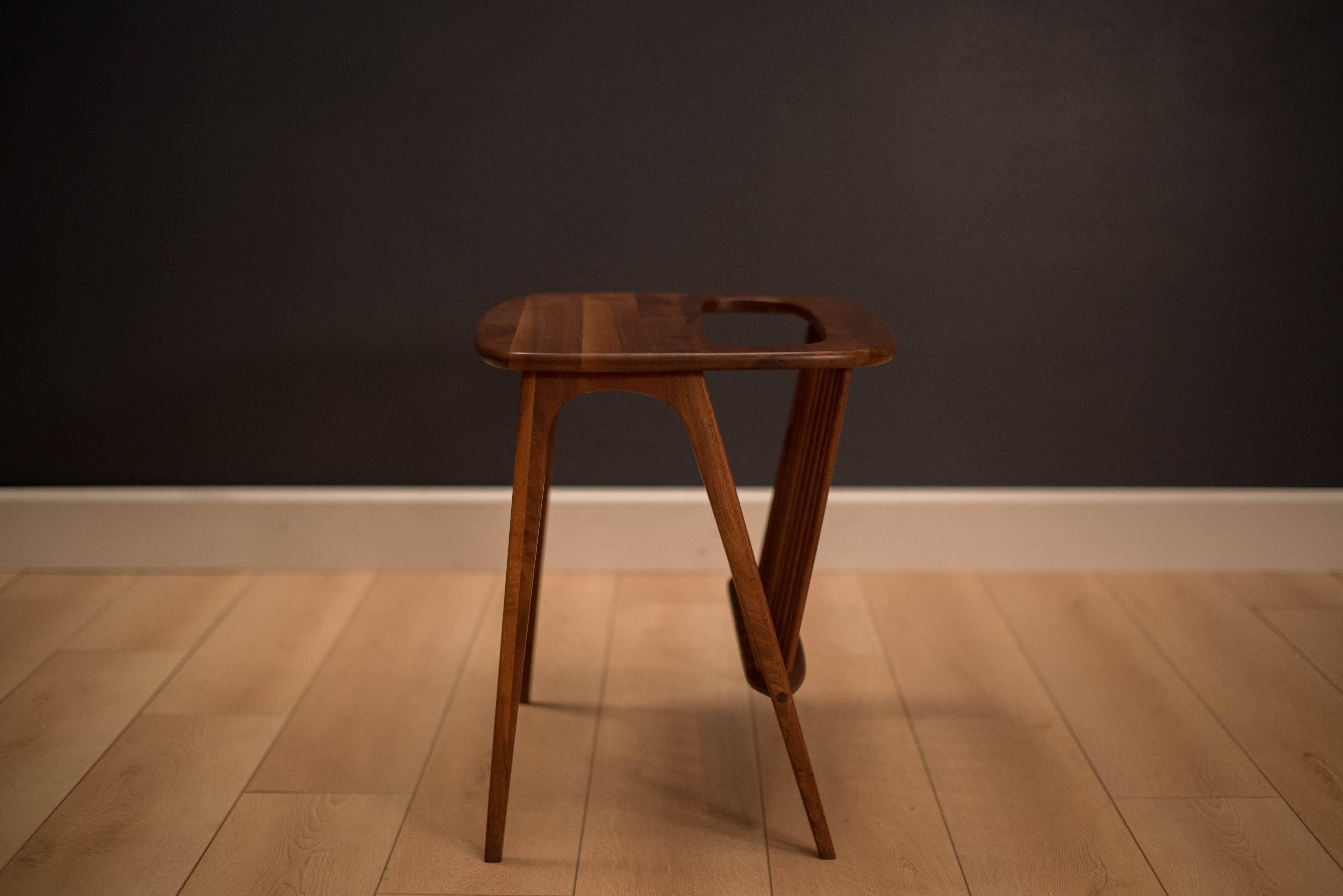 Mid-Century side table with attached magazine rack. This functional piece is designed by Arthur Umanoff and is made of solid walnut. 

 