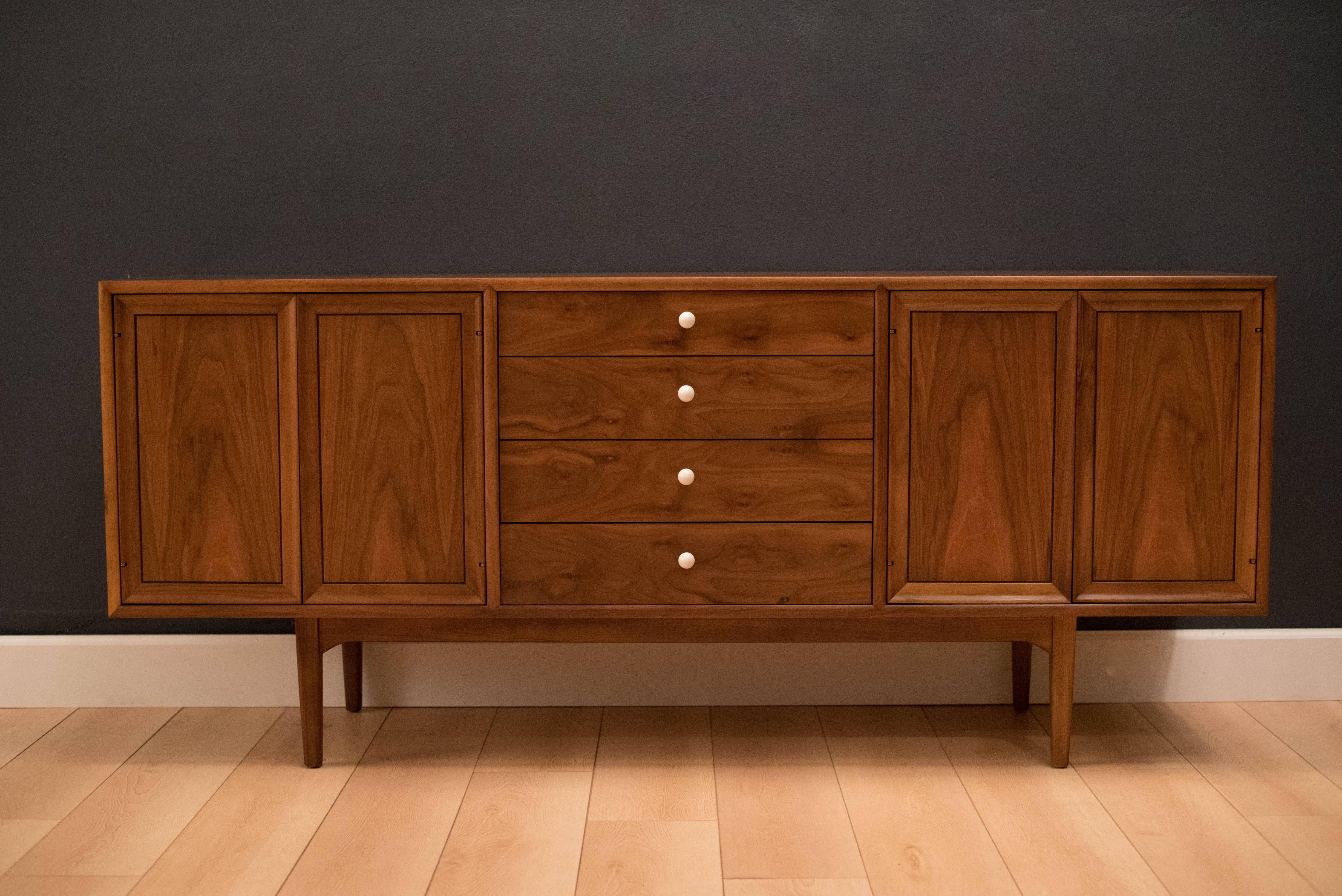 Mid-Century Drexel Declaration sideboard credenza by Kipp Stewart and Stewart McDougall. This piece features bookmatched black walnut grains highlighted by their signature white porcelain pulls. Equipped with four drawers and open storage with