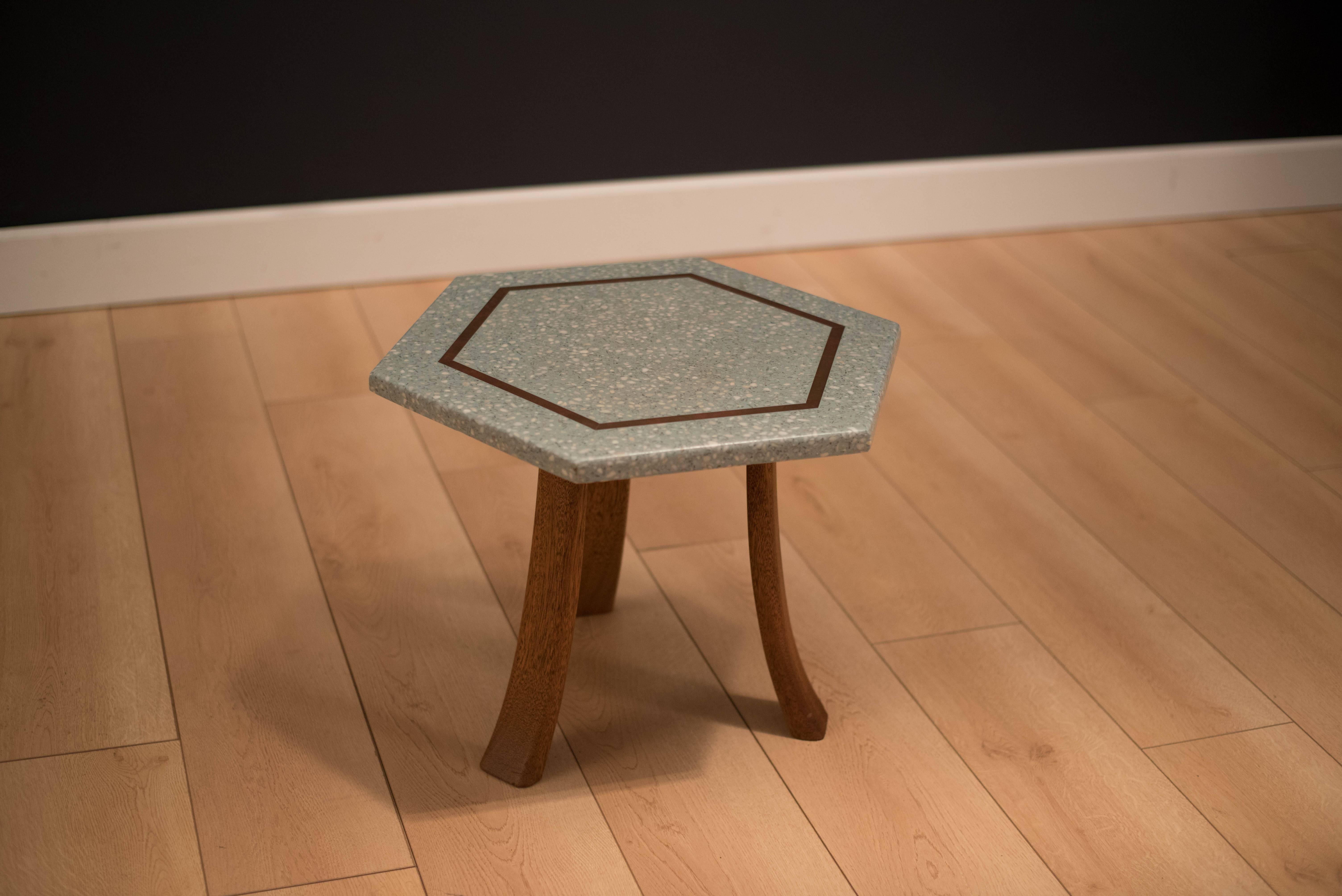 Mid-Century hexagonal side table designed by Harvey Probber. This piece displays a turquoise blue terrazzo top with brass inlay and sits on three solid sculpted mahogany legs. 

                   