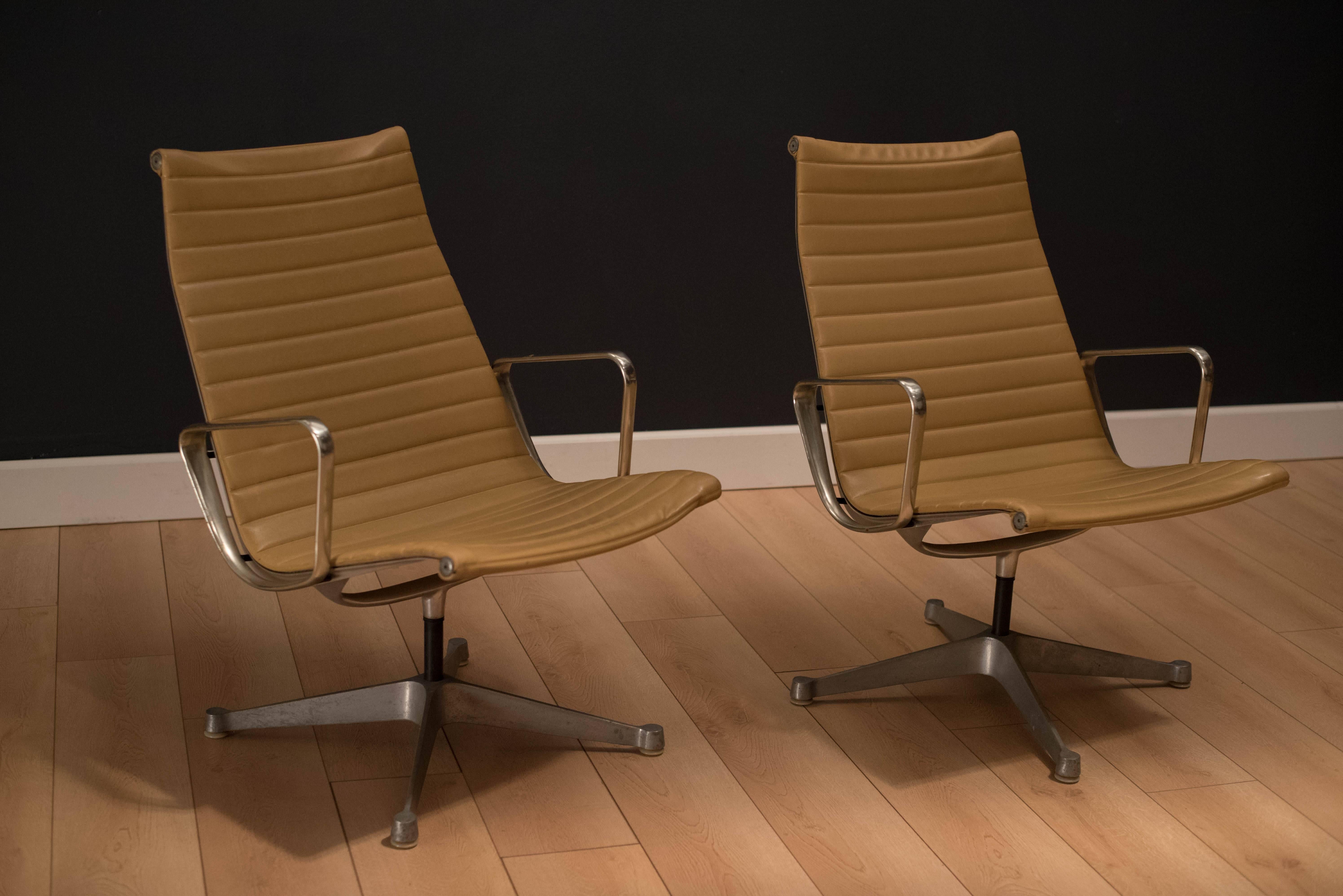 Pair of Aluminum Group swivel chairs designed by Charles and Ray Eames for Herman Miller. Original tan Naugahyde upholstery with aluminum arms. Price is for the pair. 

 