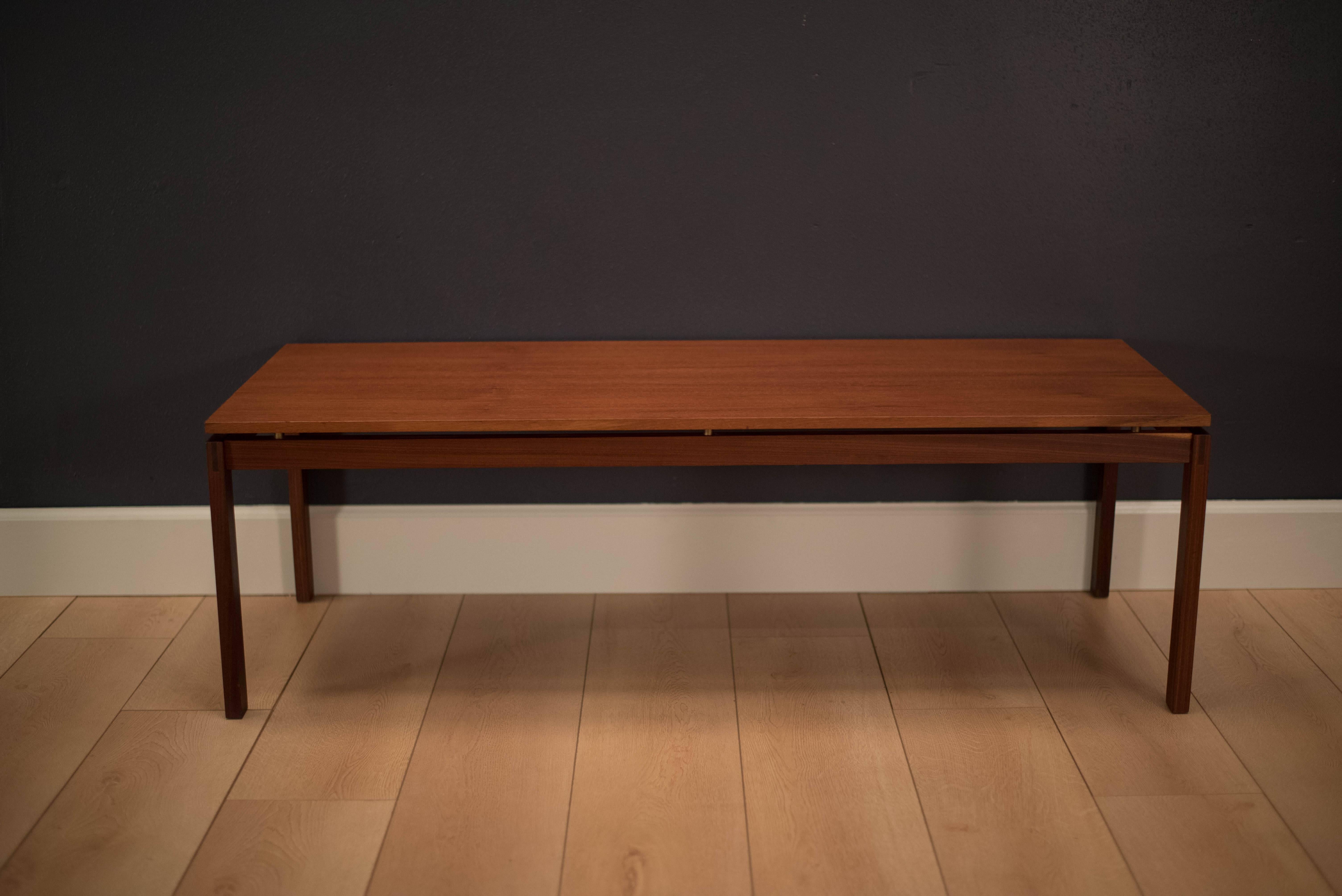 Mid-Century teak coffee table designed by Hans Olsen. This piece features a simple Minimalist design with brass accents.
          
        