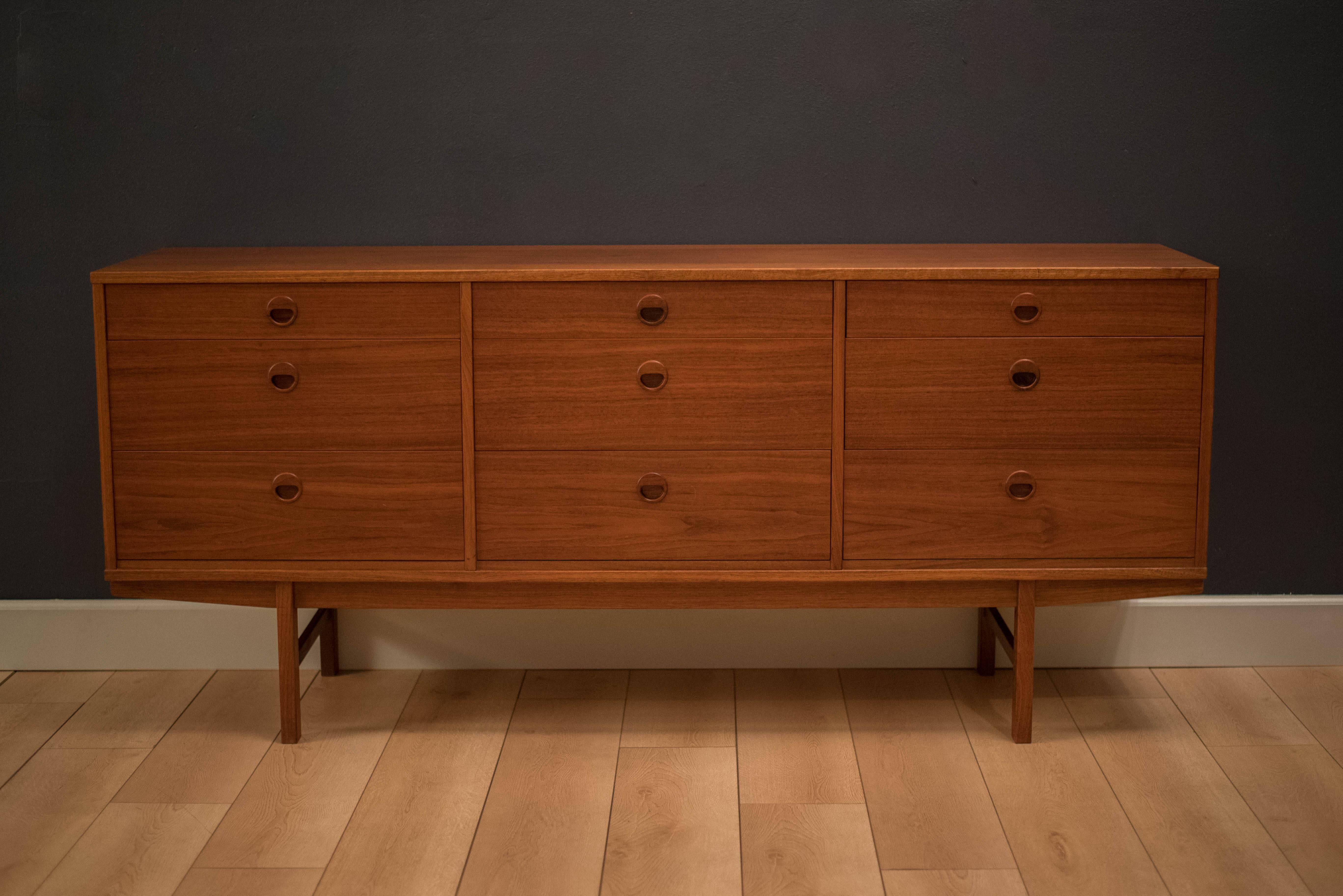 Mid-Century Modern teak dresser manufactured by DUX. This piece features nine dovetailed drawers with sculpted pulls. Top middle drawer contains drawer dividers. 

                