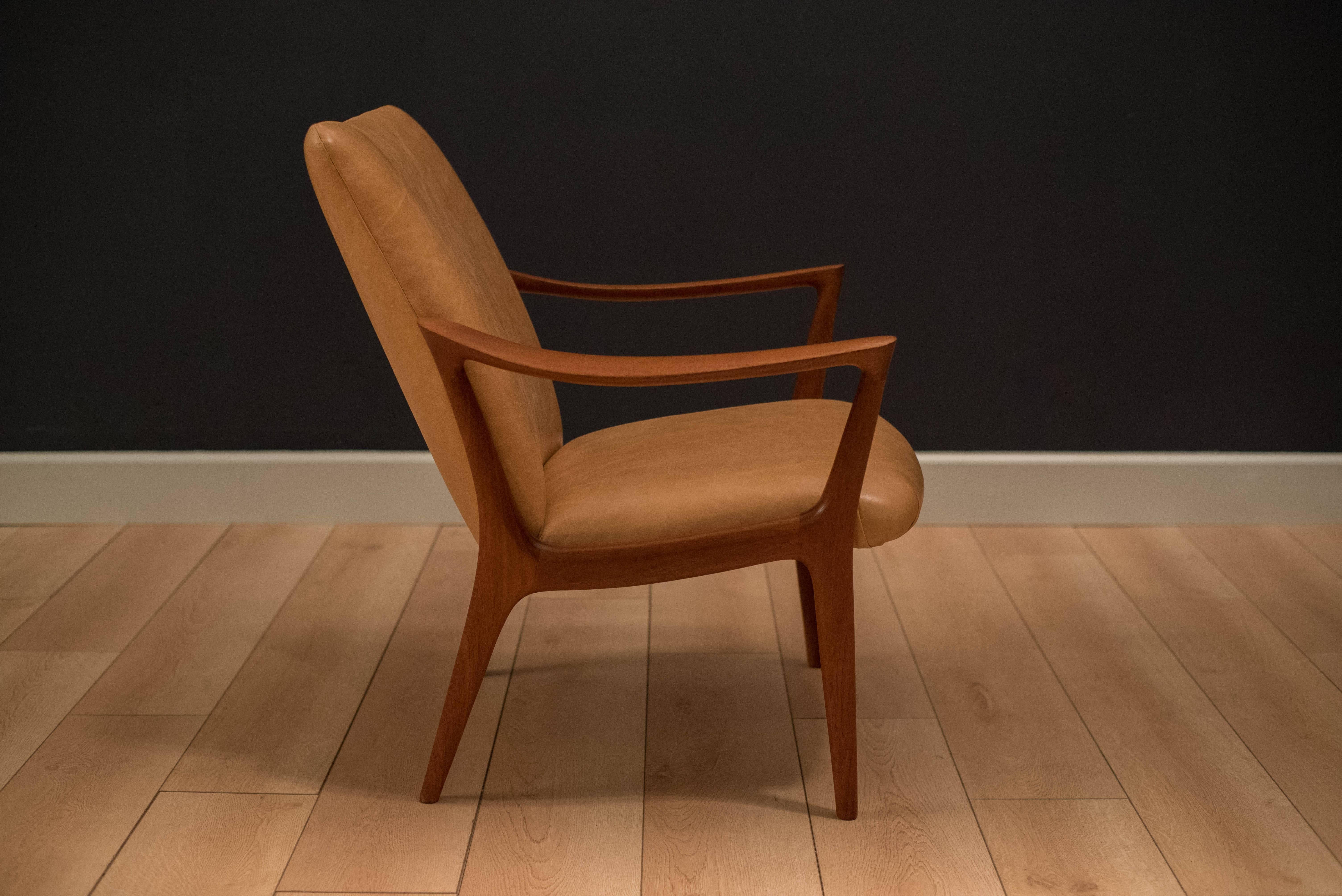 Mid-Century Modern teak armchair by Per Øie made in Norway. This piece features a stunning solid sculpted teak frame and has been reupholstered in tan leather. 

