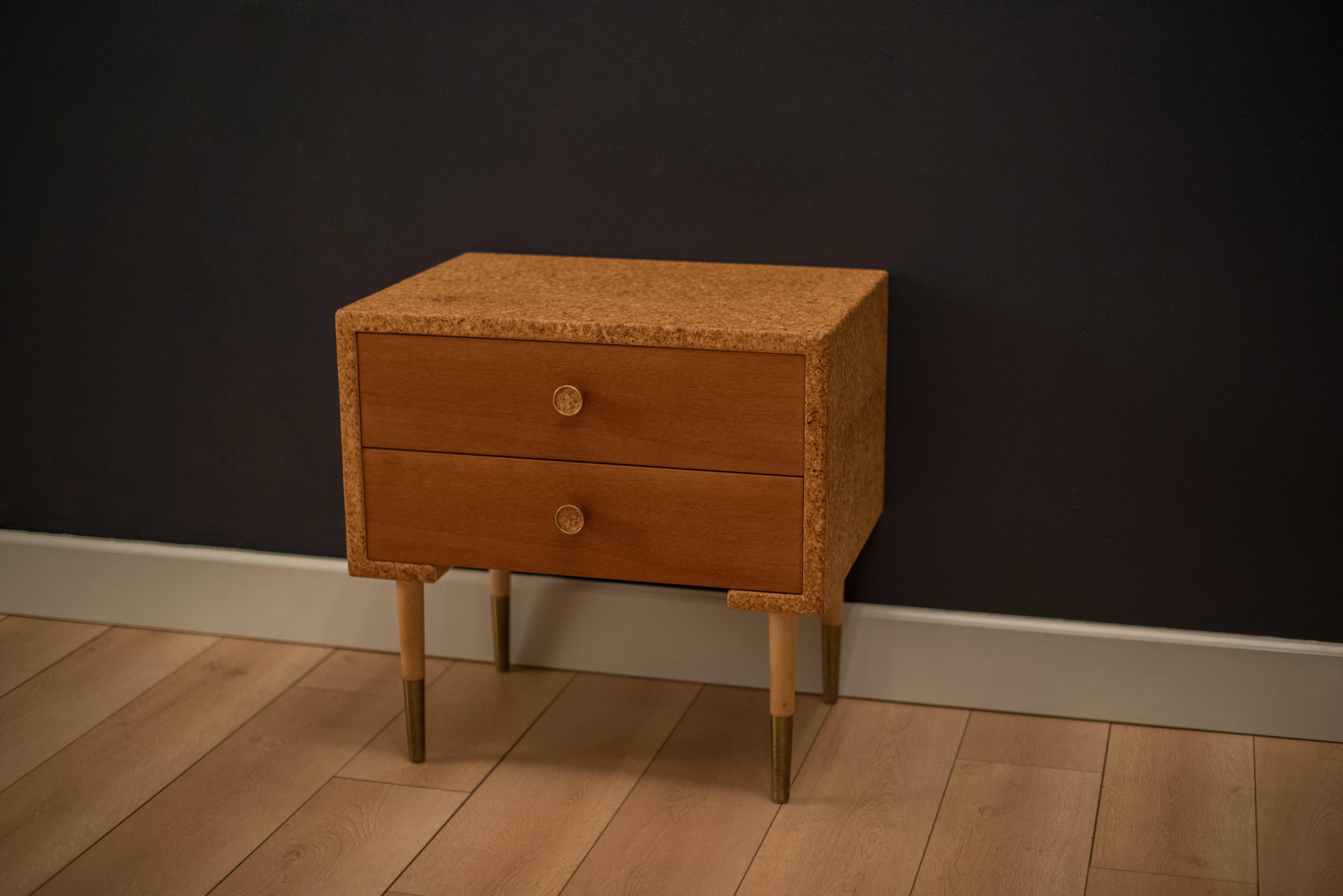 Mid-Century nightstand designed by Paul Frankl for Johnson Furniture. This unique piece is made from cork and mahogany with brass accents. Includes two dovetailed drawers with cork pulls. 

  