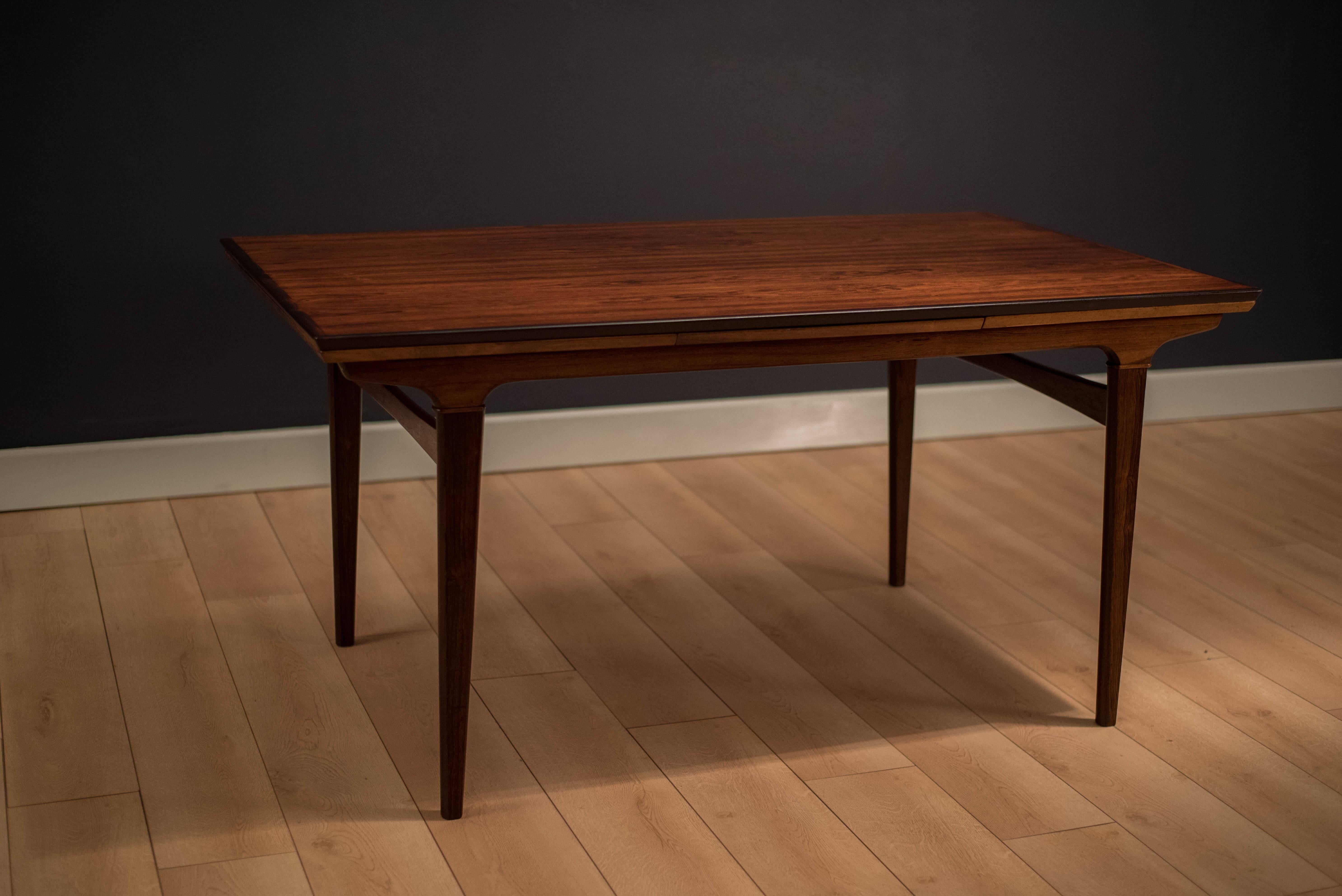 Danish modern expandable dining in Brazilian rosewood, circa 1960s. This piece features a gorgeous rosewood grain top with unique tapered legs. Extension leaves store underneath when not in use. 

Dimensions: 98