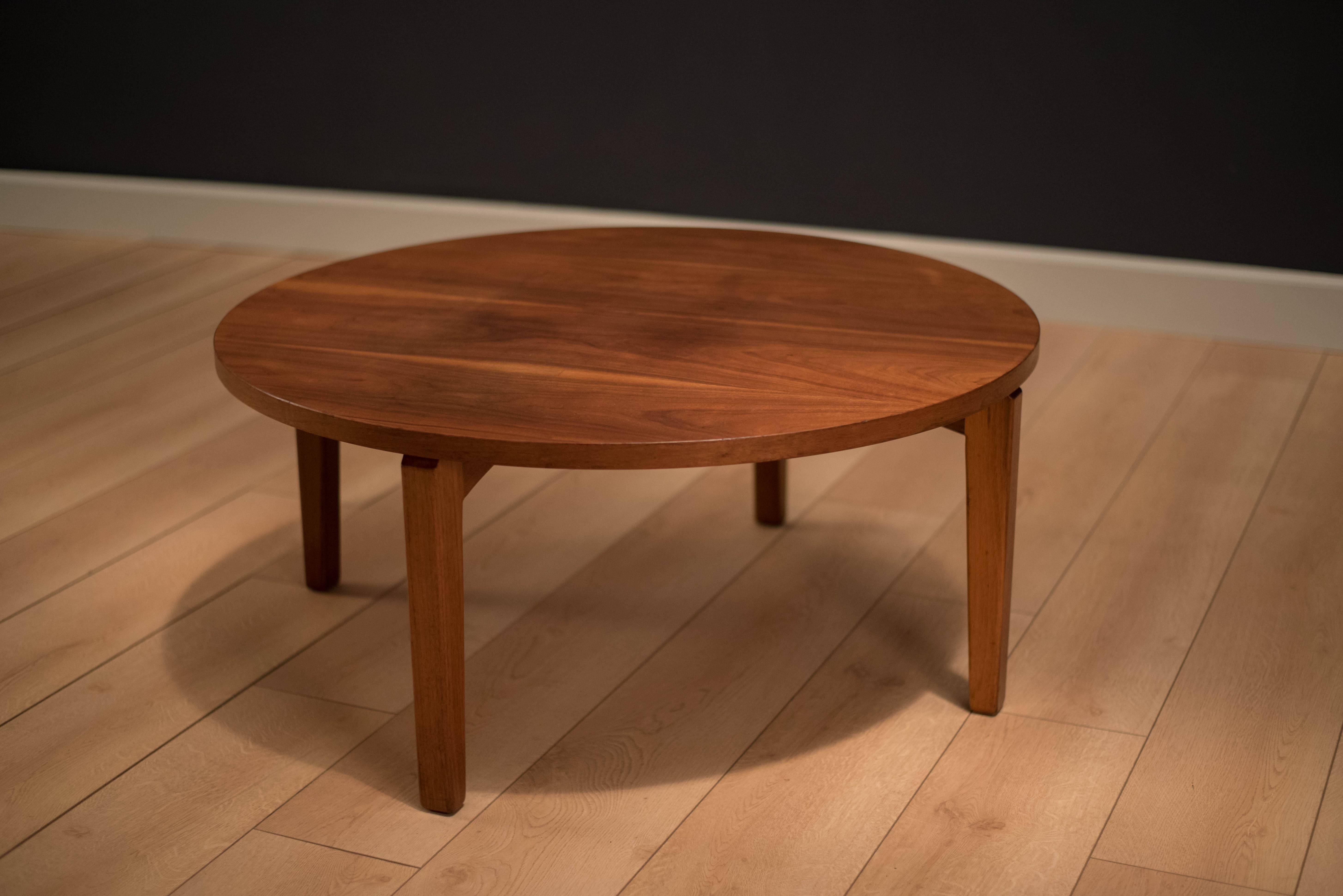 Mid-Century round coffee table in walnut manufactured by B.L. Marble Furniture. This piece features a unique modern base and a warm walnut grain top.