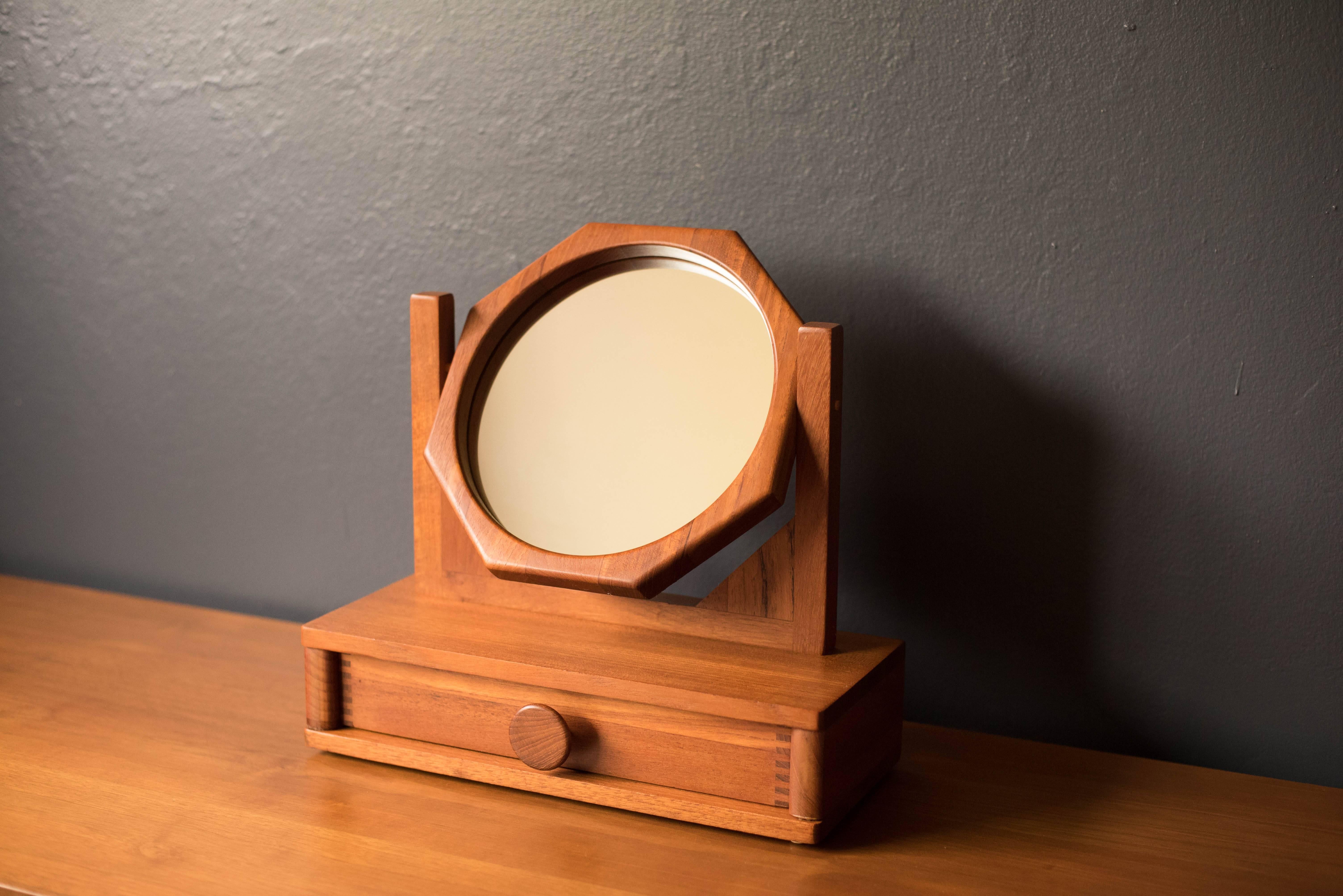 Mid Century Modern jewelry box with mirror in solid teak. This handcrafted piece features dovetailed joinery and excellent craftsmanship. Includes one storage drawer with an adjustable tilting mirror. 

  .