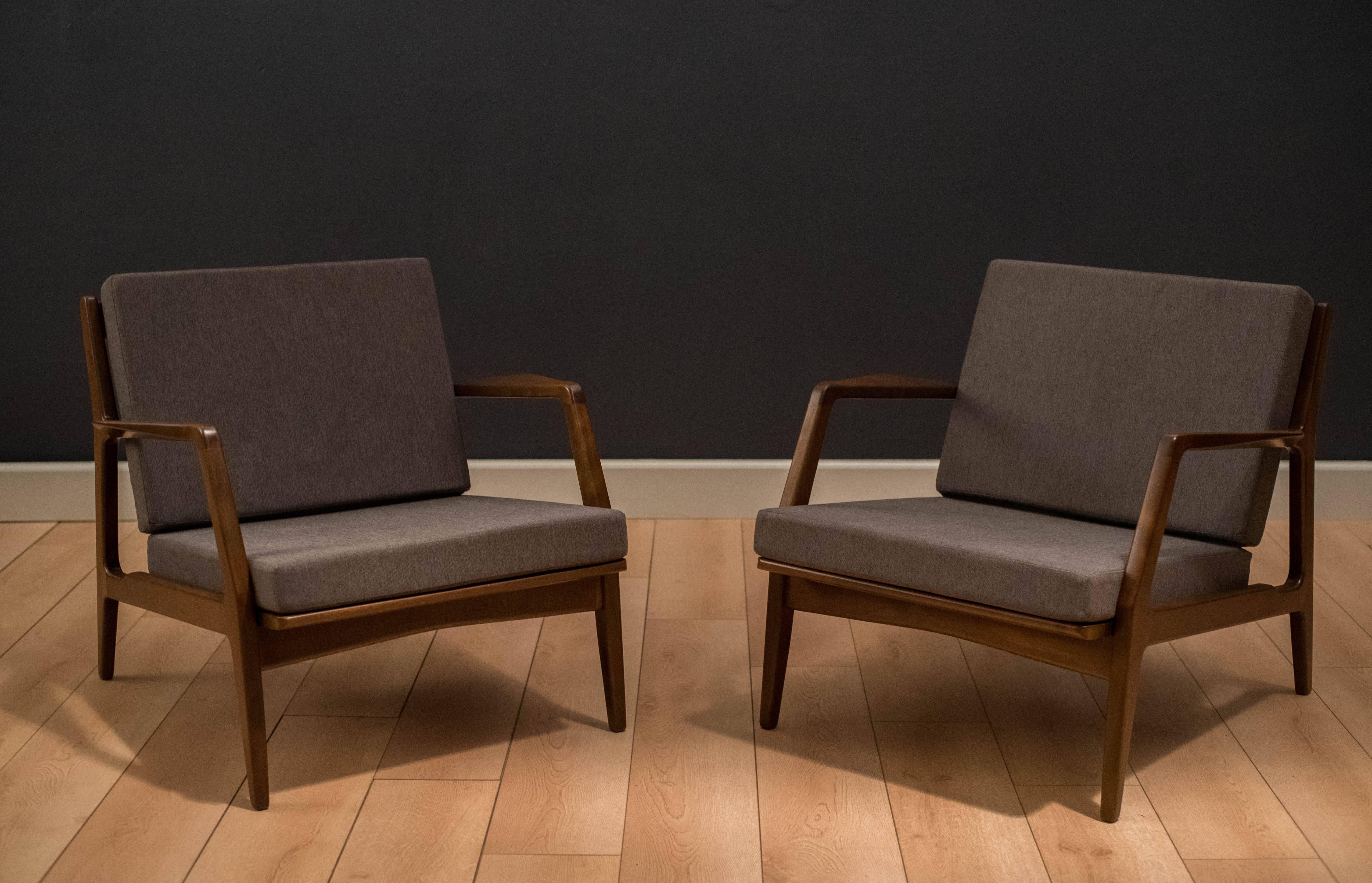 Danish modern lounge chairs designed by Ib Kofod Larsen for Selig. This pair has been professionally reupholstered in a charcoal grey fabric with brand new foam. Includes original webbing and price is for the pair. 



