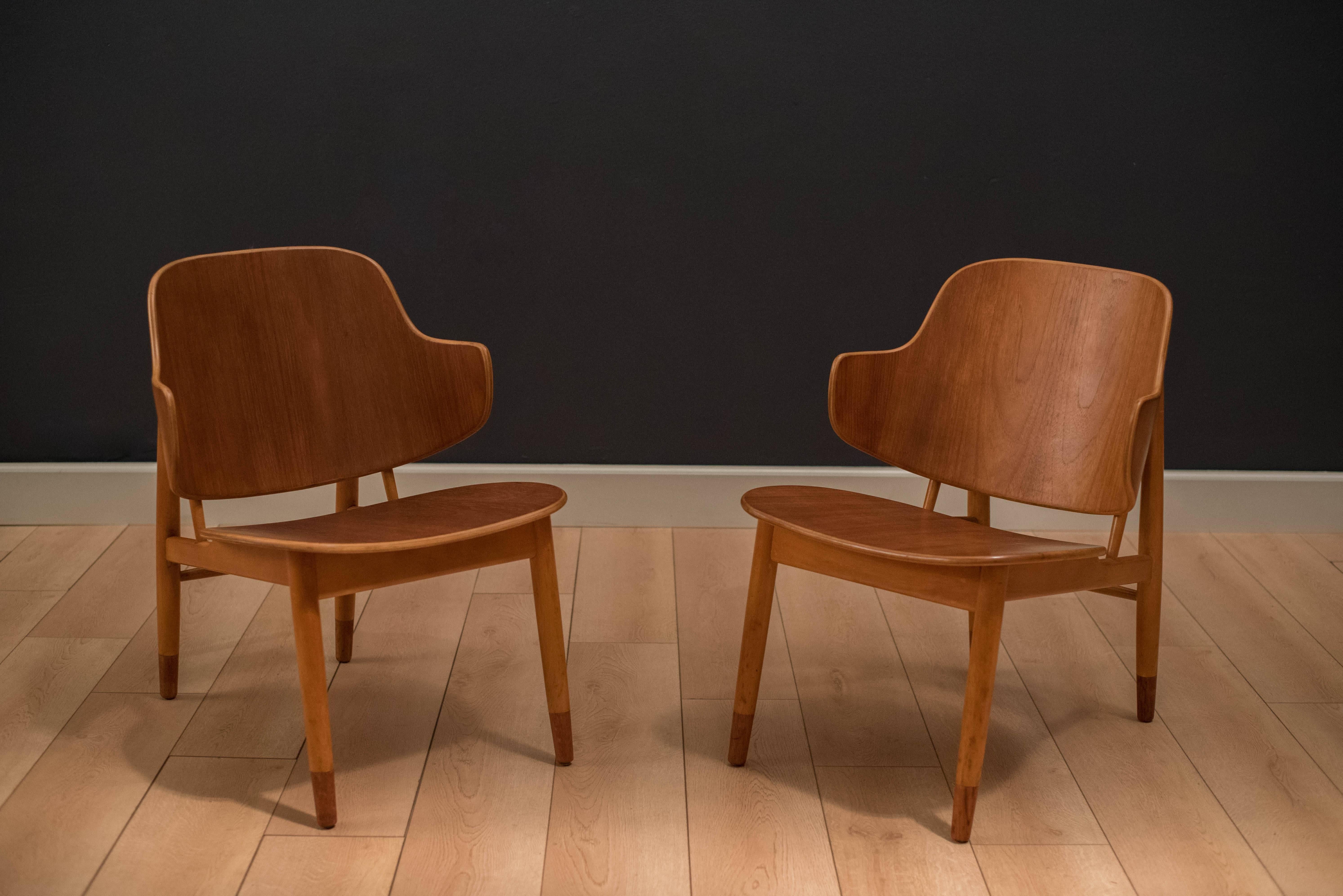 Mid-Century shell chairs designed by Ib Kofod-Larsen. This pair features a sculpted bent seat and backrest with contrasting teak and birch finishes. 

