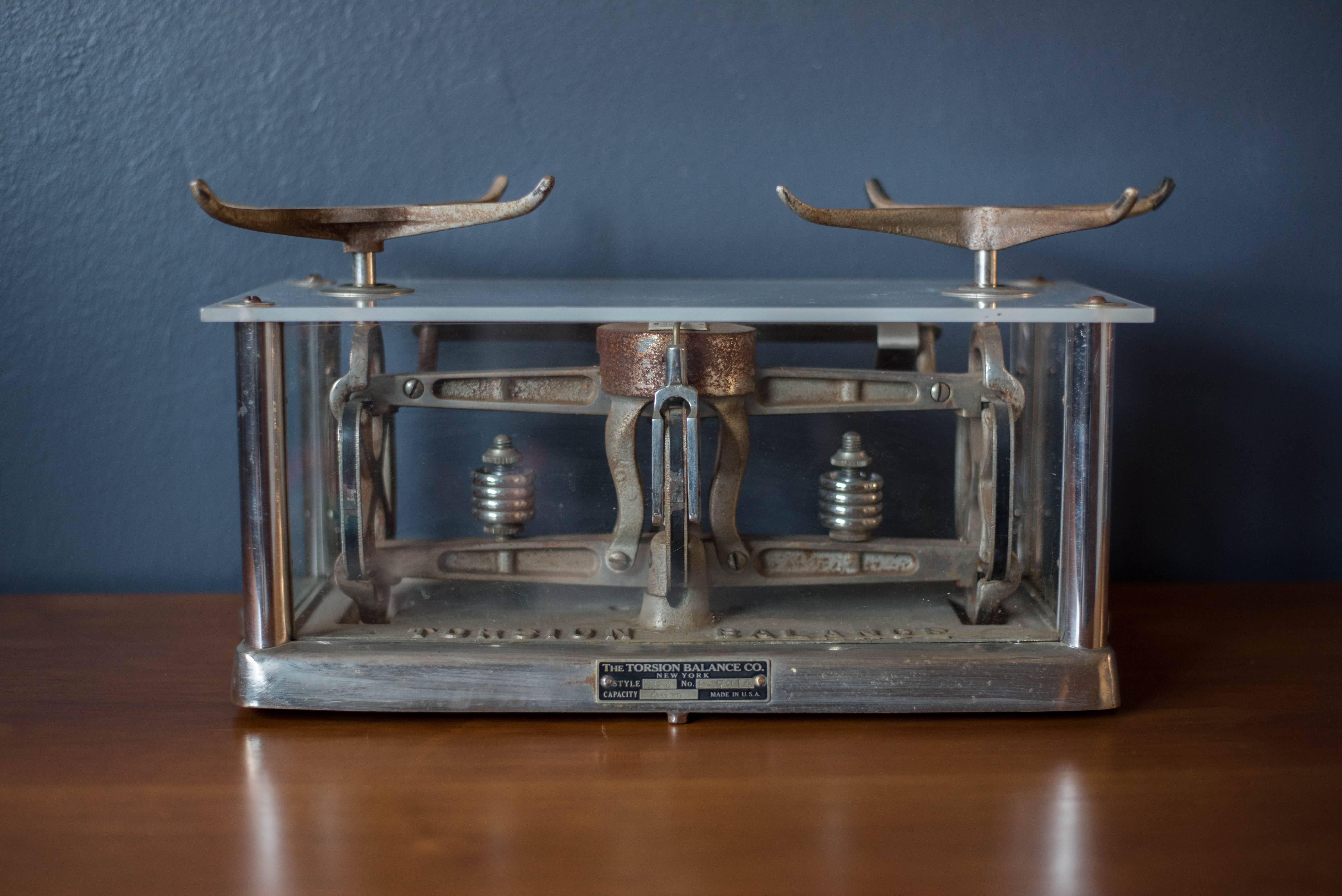 Industrial apothecary pharmaceutical torsion balance scale from the early 1900s. Balance is encased in glass and metal with a plexiglass top.