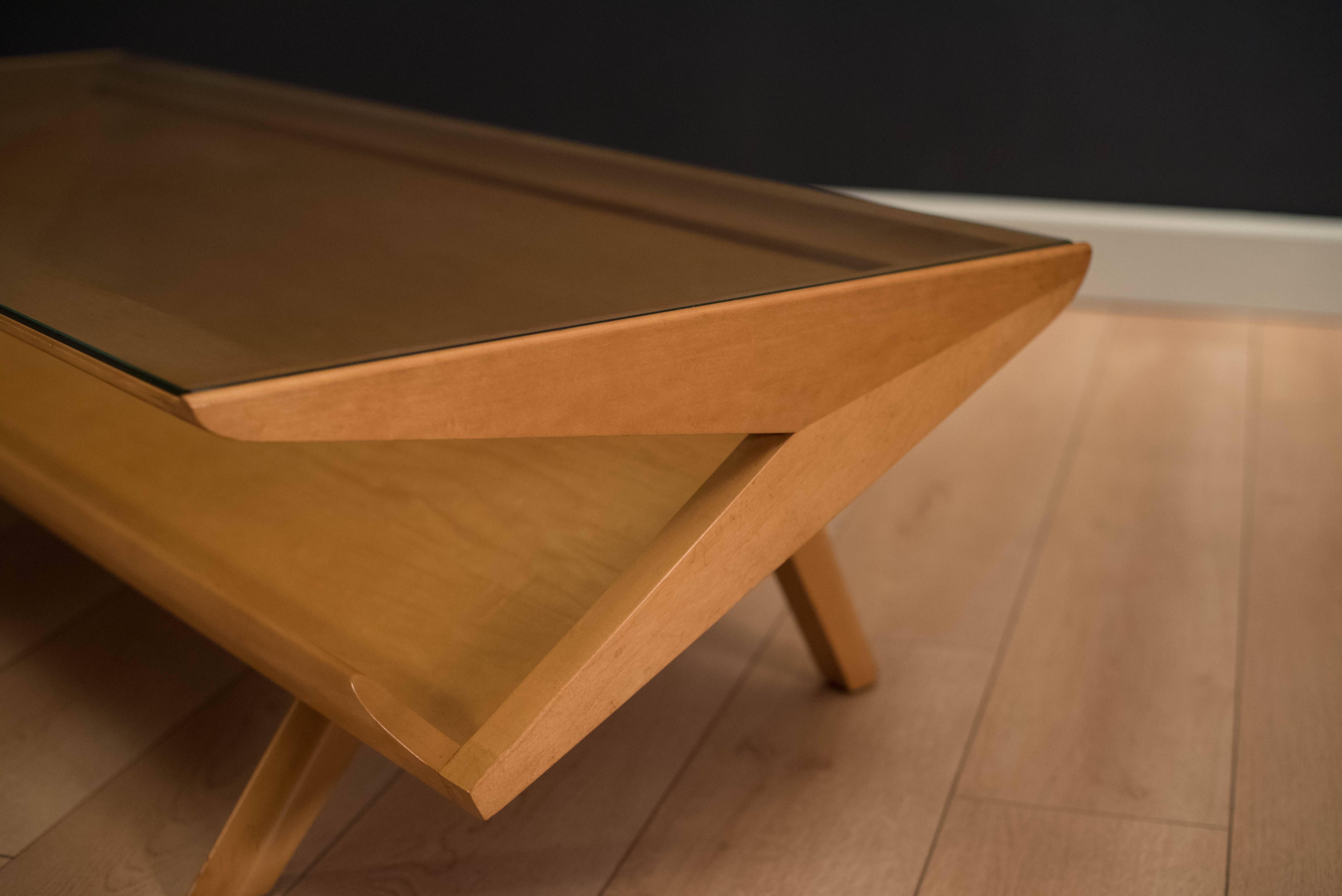 Mid-Century Modern coffee table by John Keal for Brown Saltman. This piece features a lower magazine shelf display and unique splayed legs.