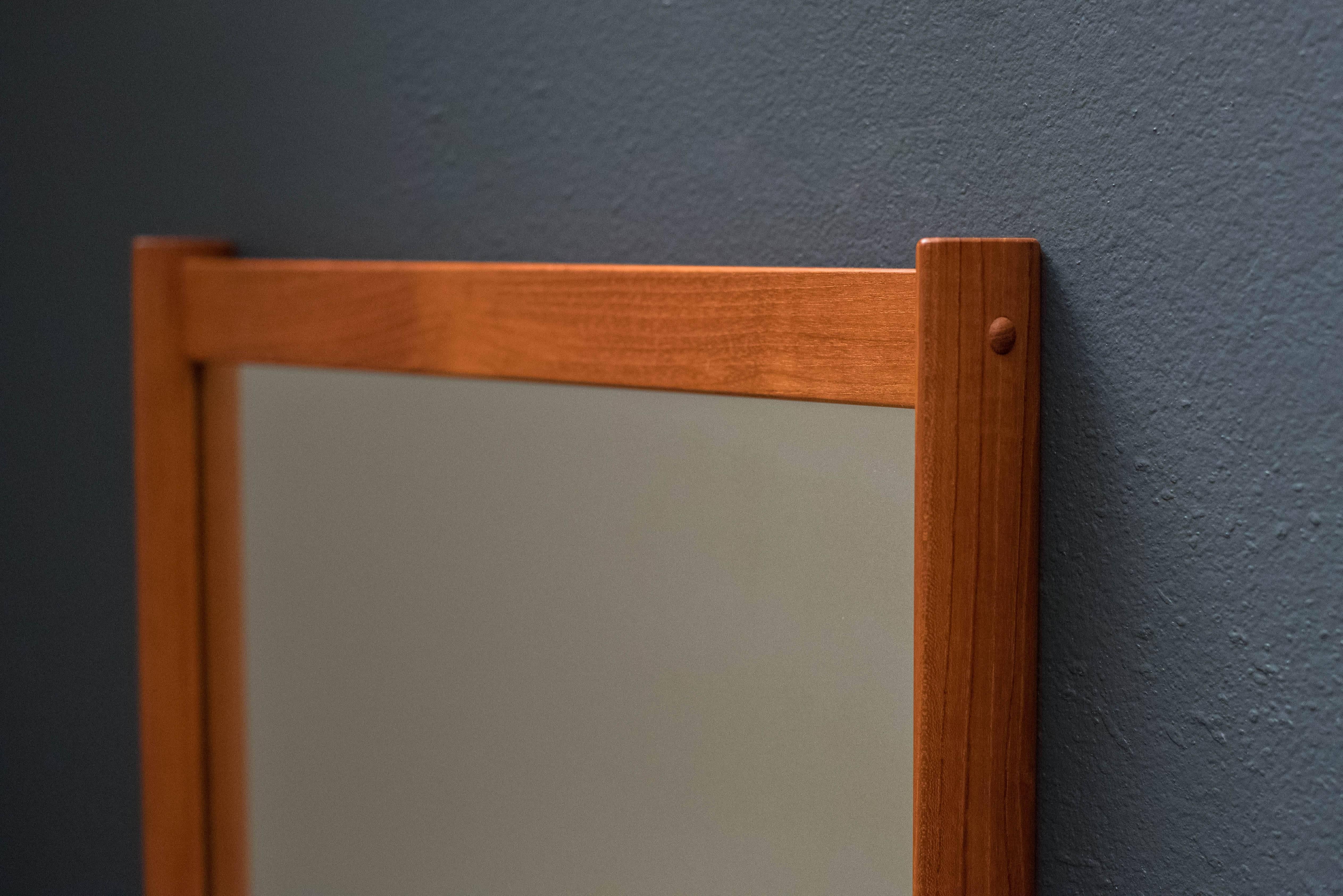 Mid-Century wall mirror designed by Aksel Kjersgaard in teak. This piece has a unique frame design featuring sculpted edges.

         