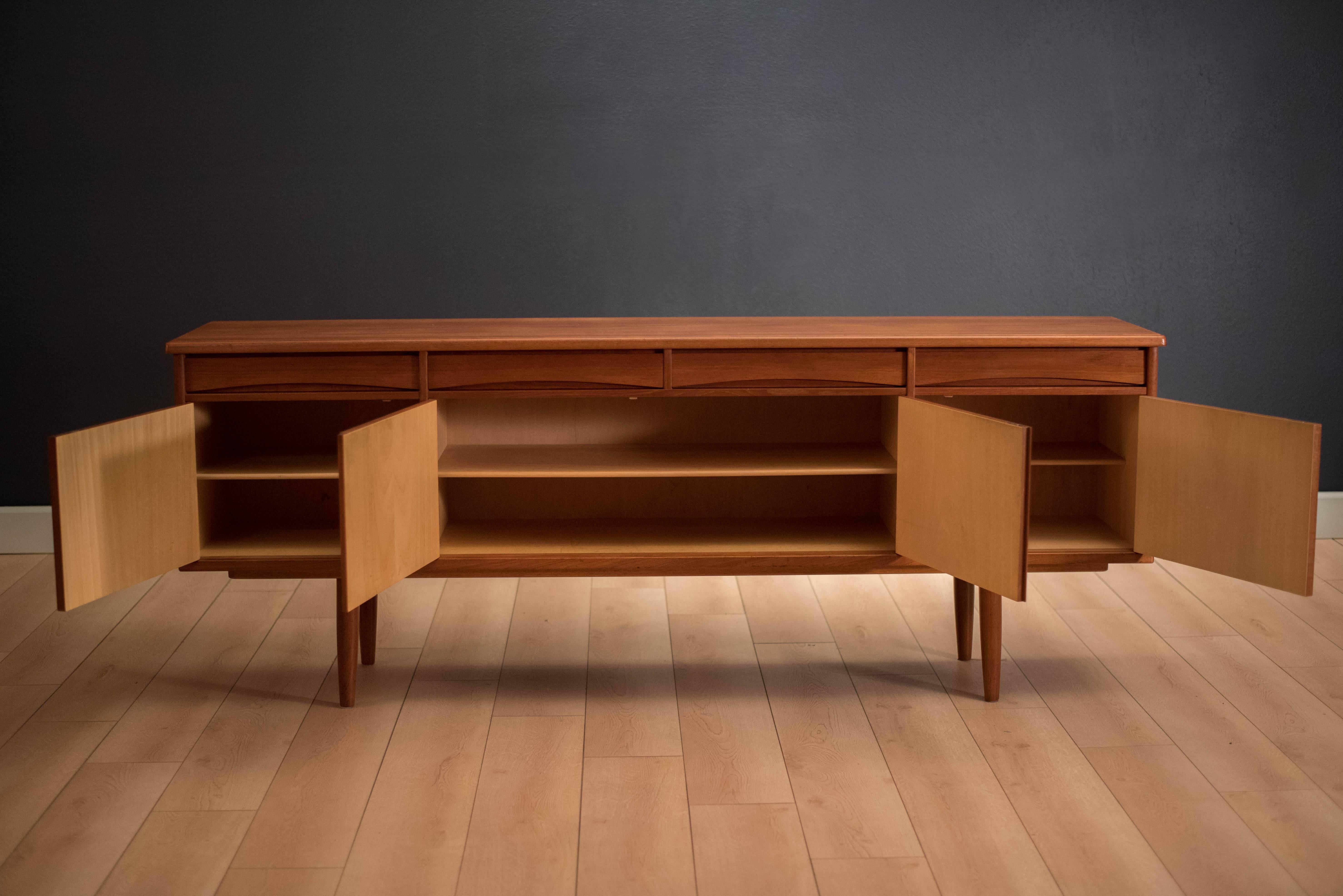 Mid-Century teak sideboard or credenza made in Norway. This piece features four drawers with unique sculpted handles and three interior cabinets with shelving. Skeleton key is included.


