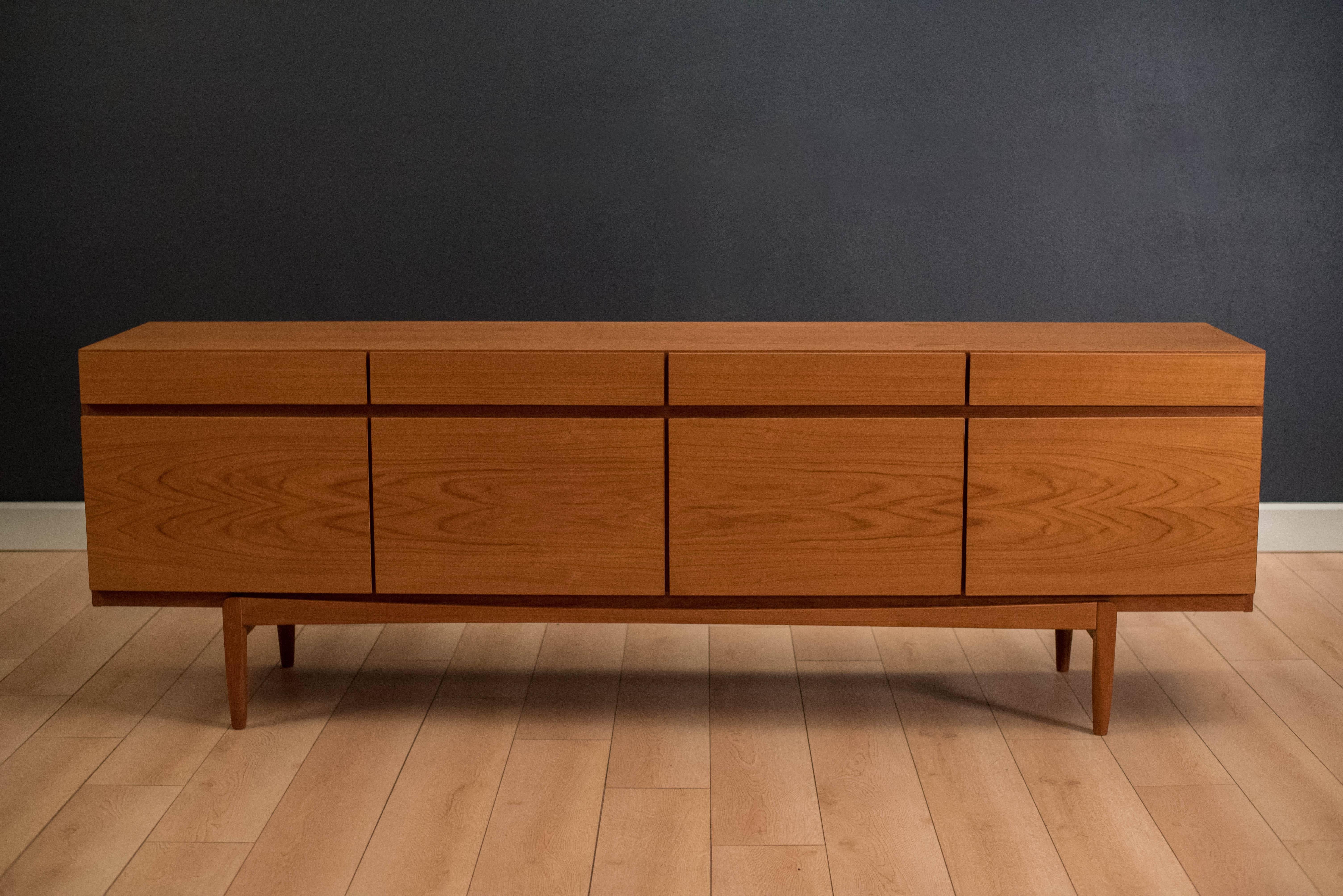 Mid-Century teak credenza designed by Ib Kofod-Larsen for Faarup Mobelfabrik. This piece provides plenty of storage space and includes four top drawers with adjustable shelving in the right three cabinets. Left cabinet includes an additional five