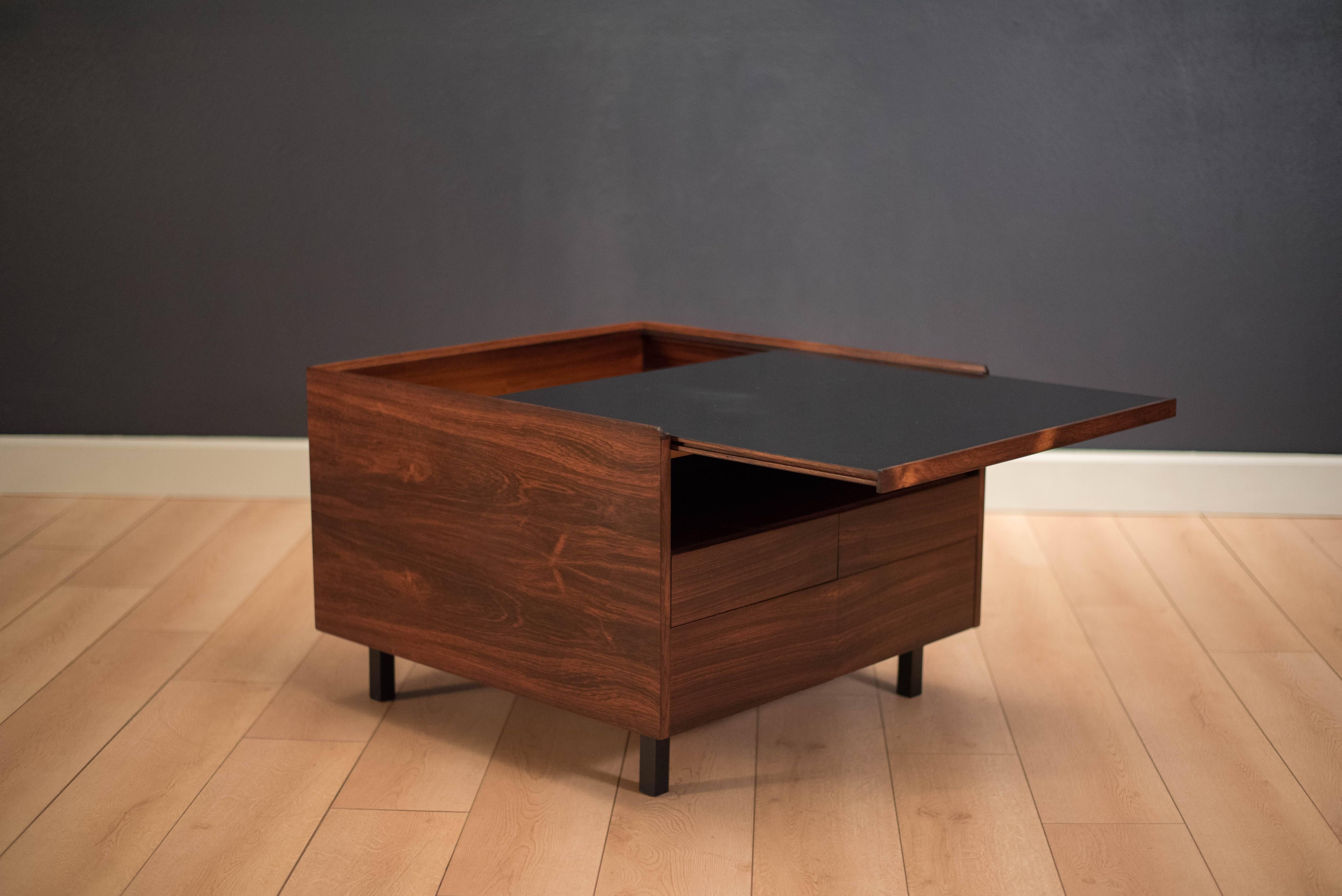 Mid-Century bar table in rosewood by Arne Vodder for Sibast. This versatile piece can be used as a coffee or occasional side table and includes four sliding drawers. Black laminate top slides to reveal hidden storage. Key is not included.