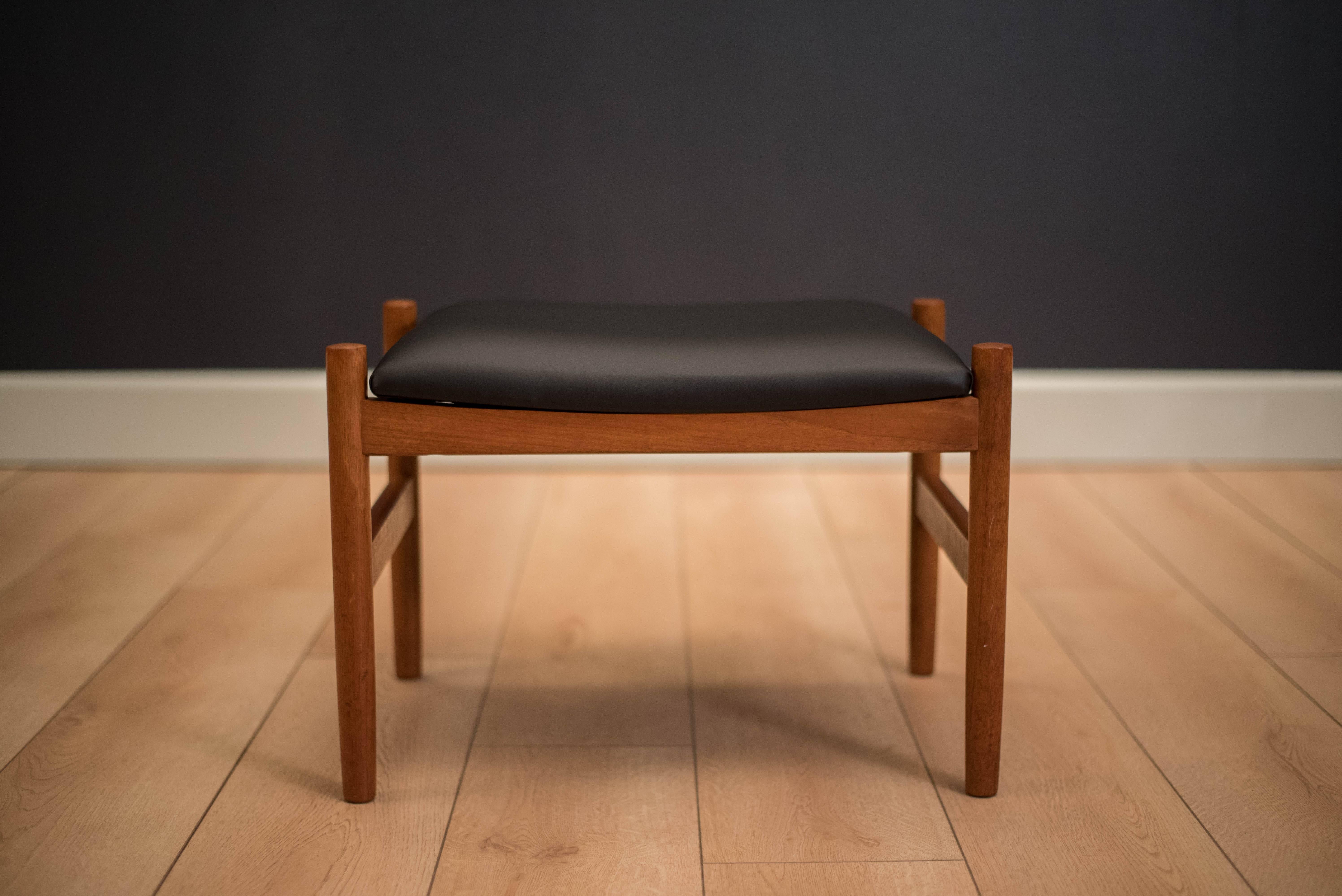 Mid-Century Modern Danish stool in teak by Spøttrup Møbelfabrik. This piece is newly reupholstered in black vinyl and functions as a footstool or an ottoman.
             