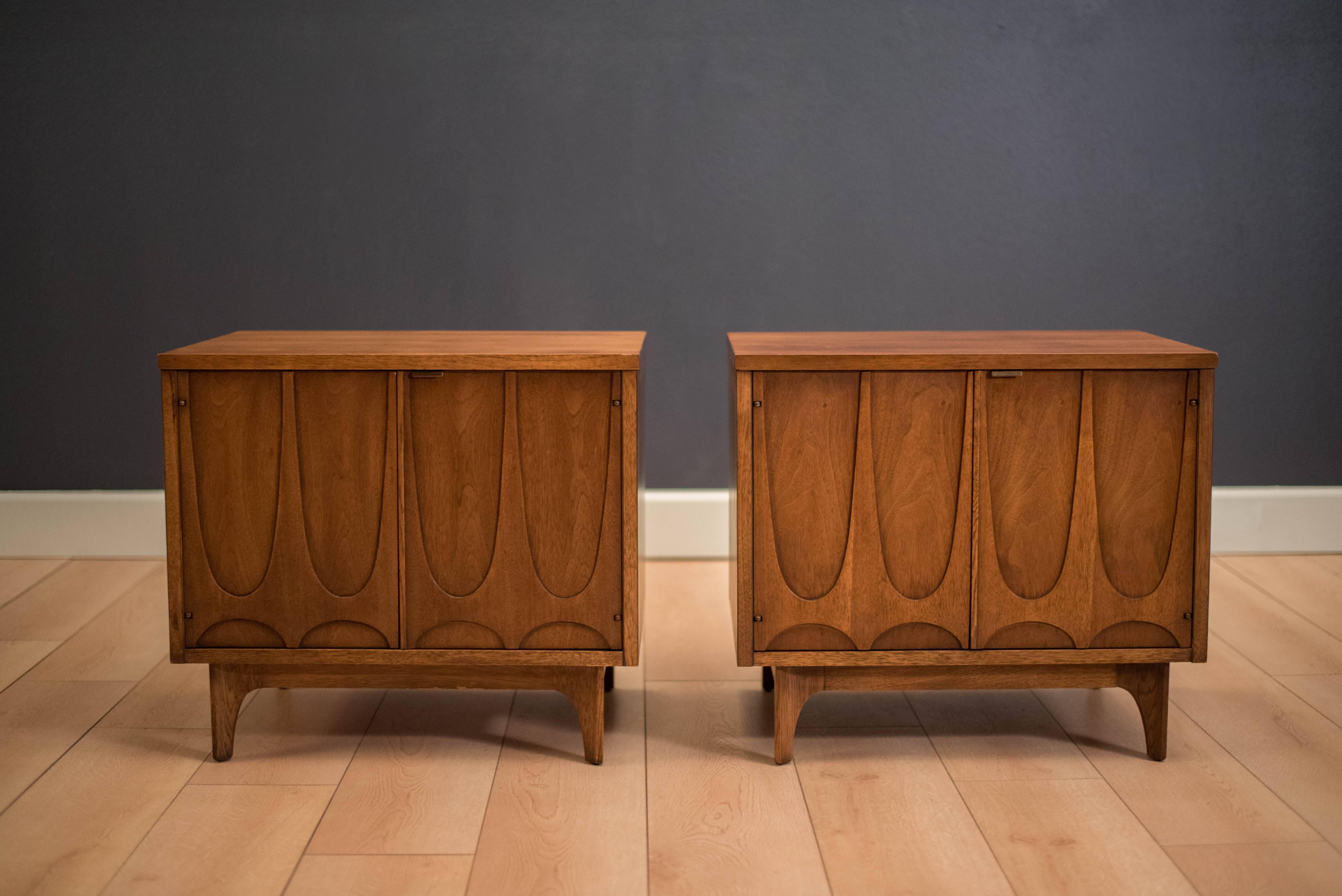 Mid-Century pair of Brasilia nightstands or commodes manufactured by Broyhill, circa 1960s. This set includes open storage space in each cabinet and features the signature sculpted arches. Price is for the pair.