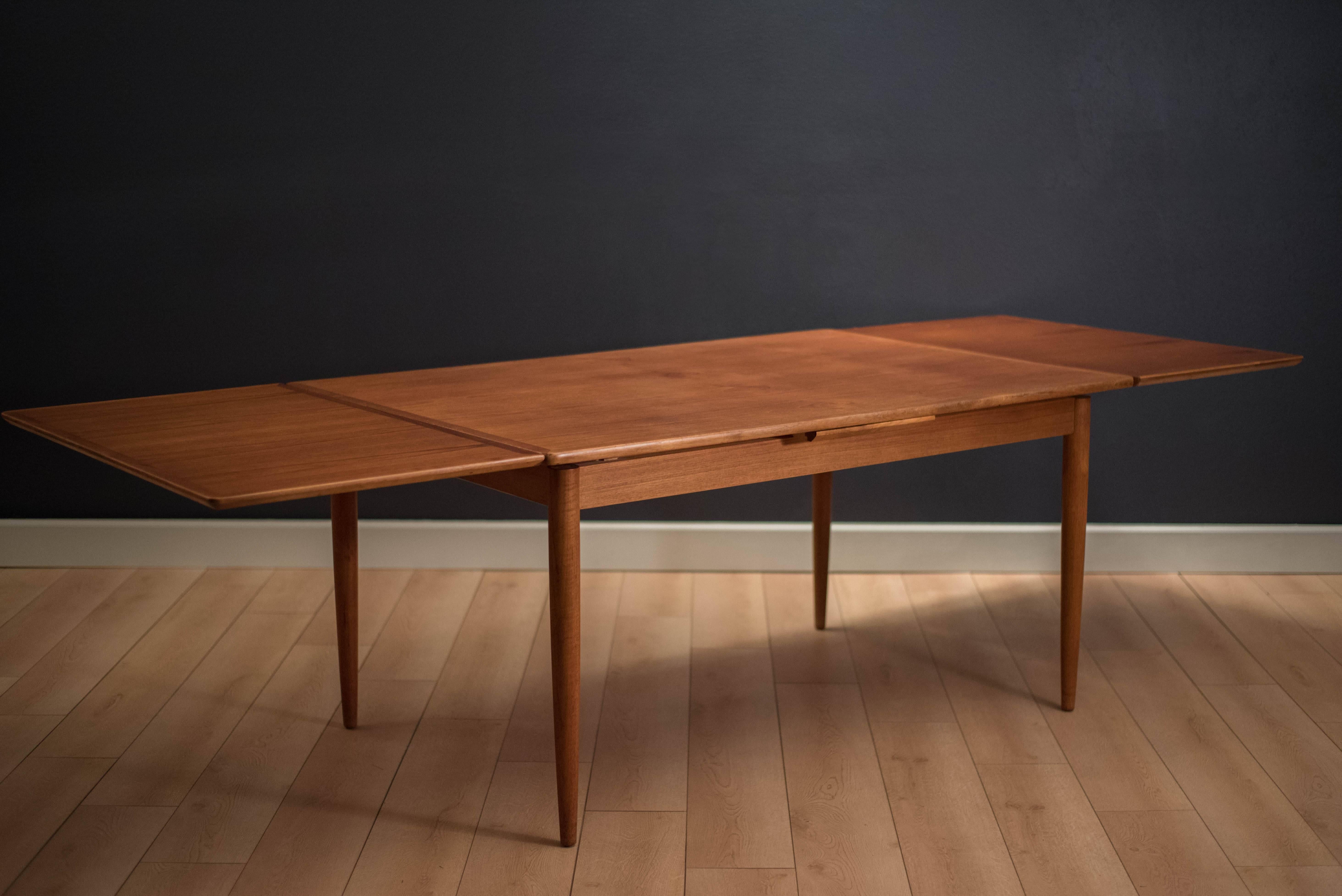 Danish Modern teak draw leaf dining table, circa 1960s. This piece expands with two leaves that cleverly store underneath table. 

Measures 106.5" fully extended.

