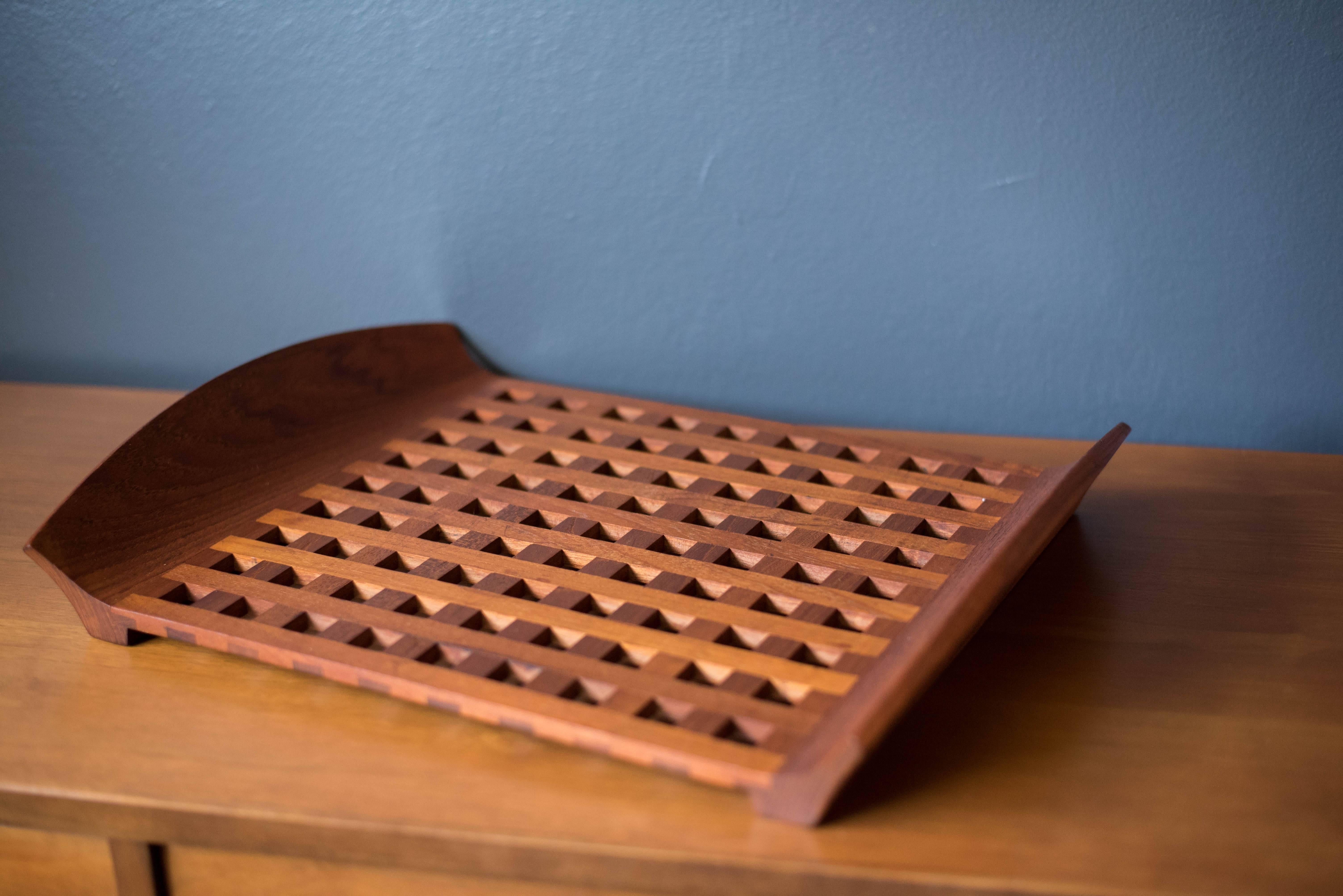 Danish lattice tray designed by Jens Quistgaard. This piece is made of solid teak and functions as a decorative trivet or serving tray. 

 