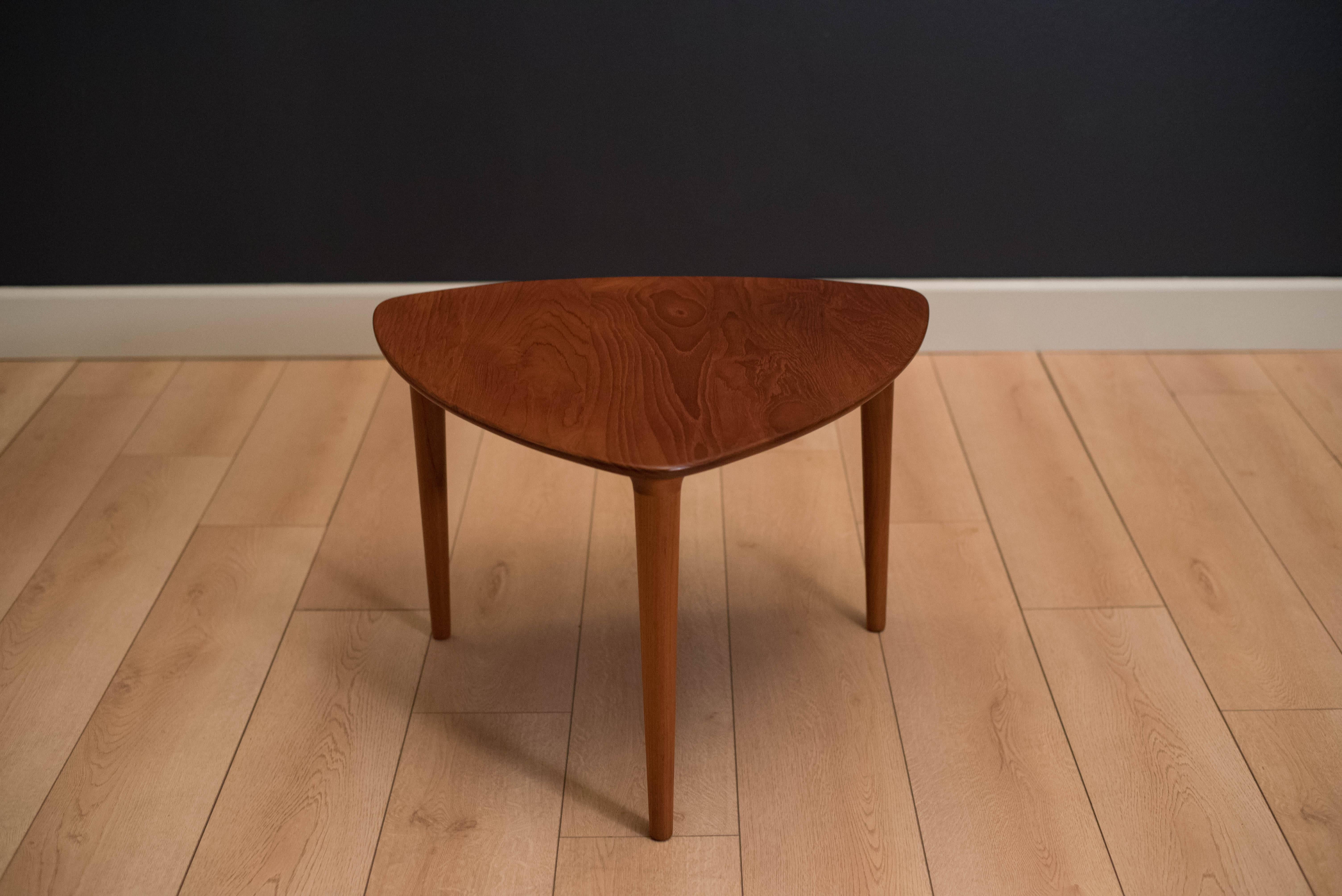 Mid-Century Modern side table manufactured by Gustav Bahus, Norway. This side table is made of solid teak and has a unique triangular guitar pick top with sculpted solid legs.