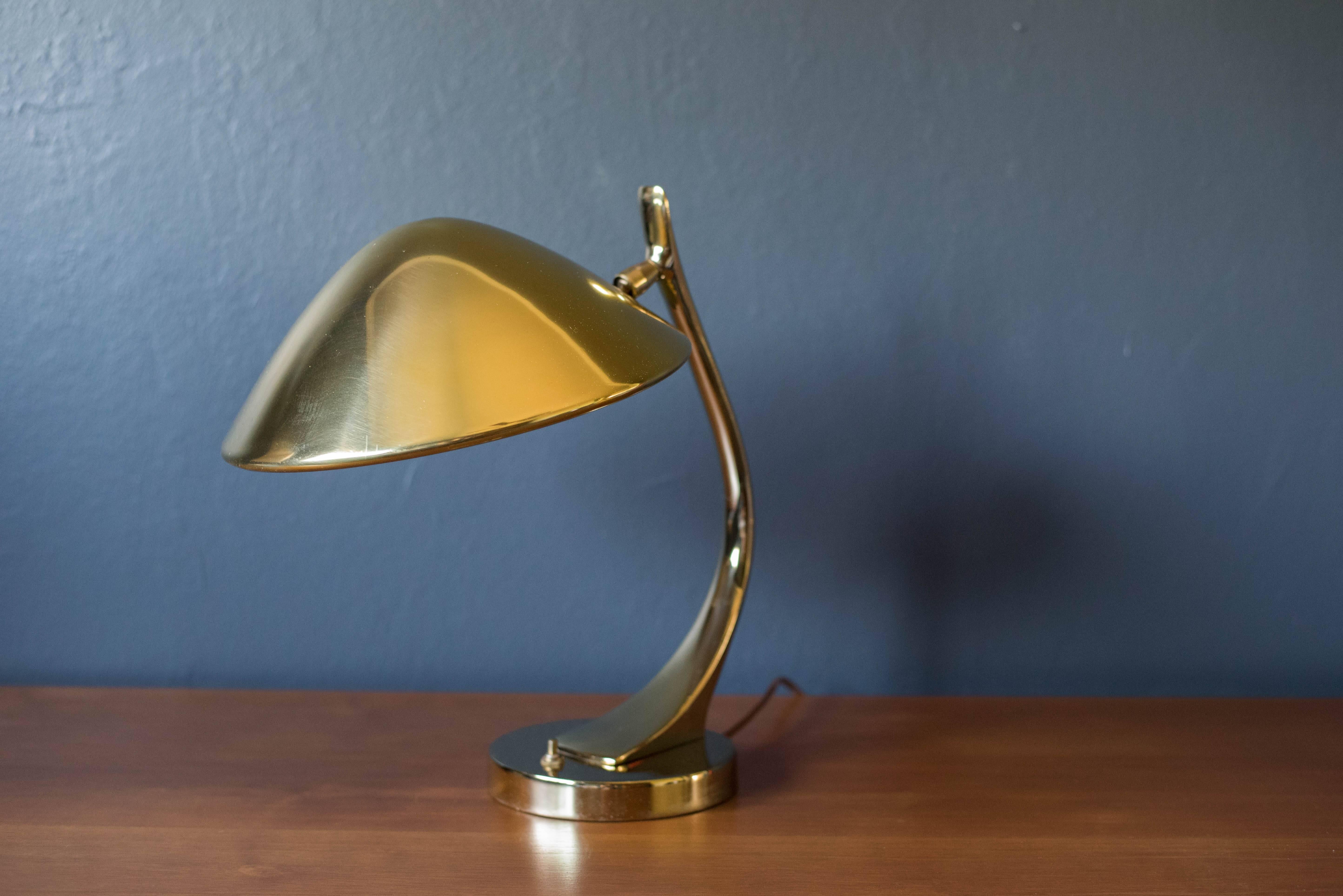 Mid-Century adjustable desk or table lamp by Laurel Lamp Co., circa 1970s. This piece is brass-plated and functions with an adjustable neck and tilting head.