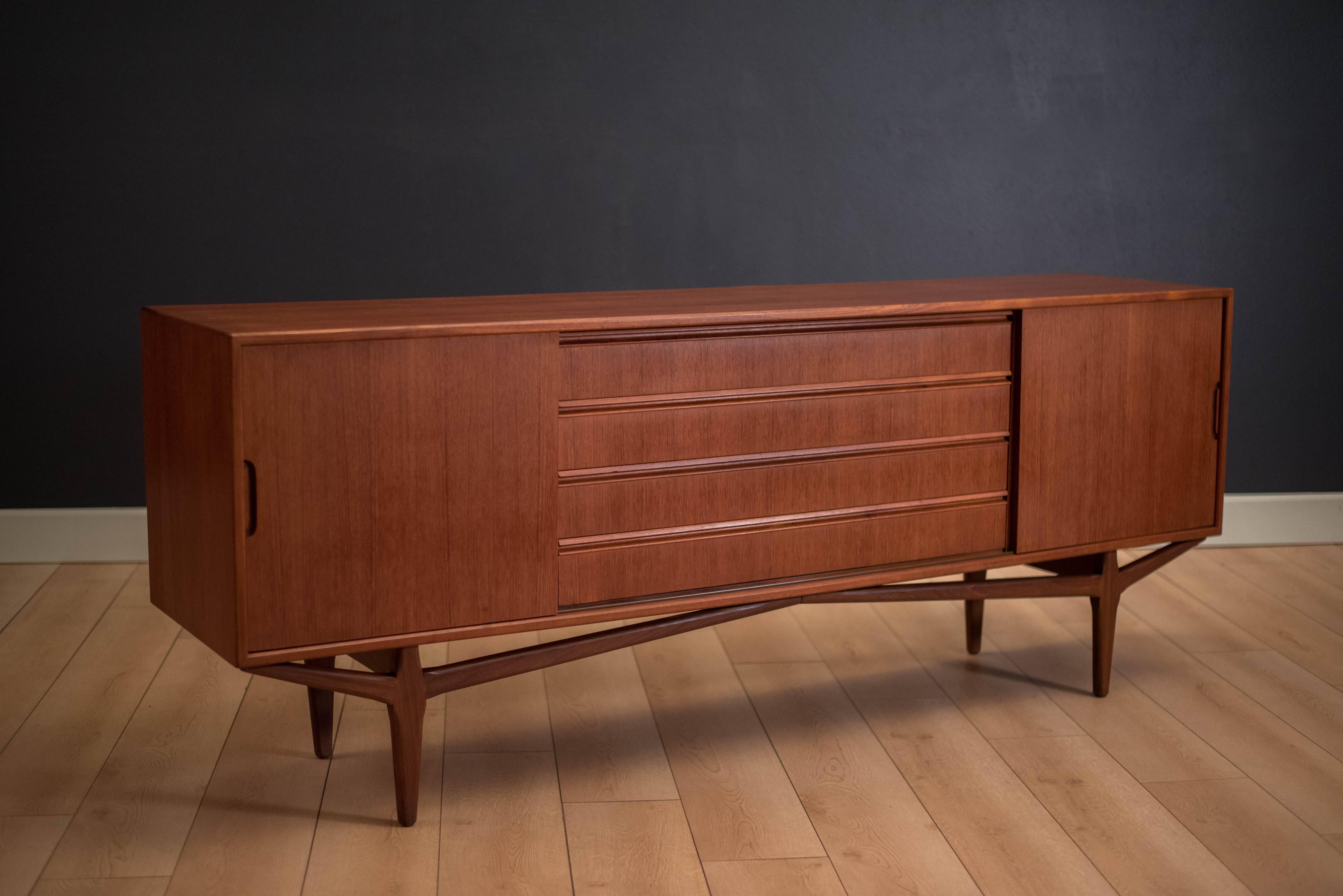 Mid-Century Modern credenza or sideboard by Knud Nielsen for Losning Mobelfabrik, circa 1960s. This piece is equipped with adjustable shelving on each side and includes four oversized dovetailed drawers. 



 