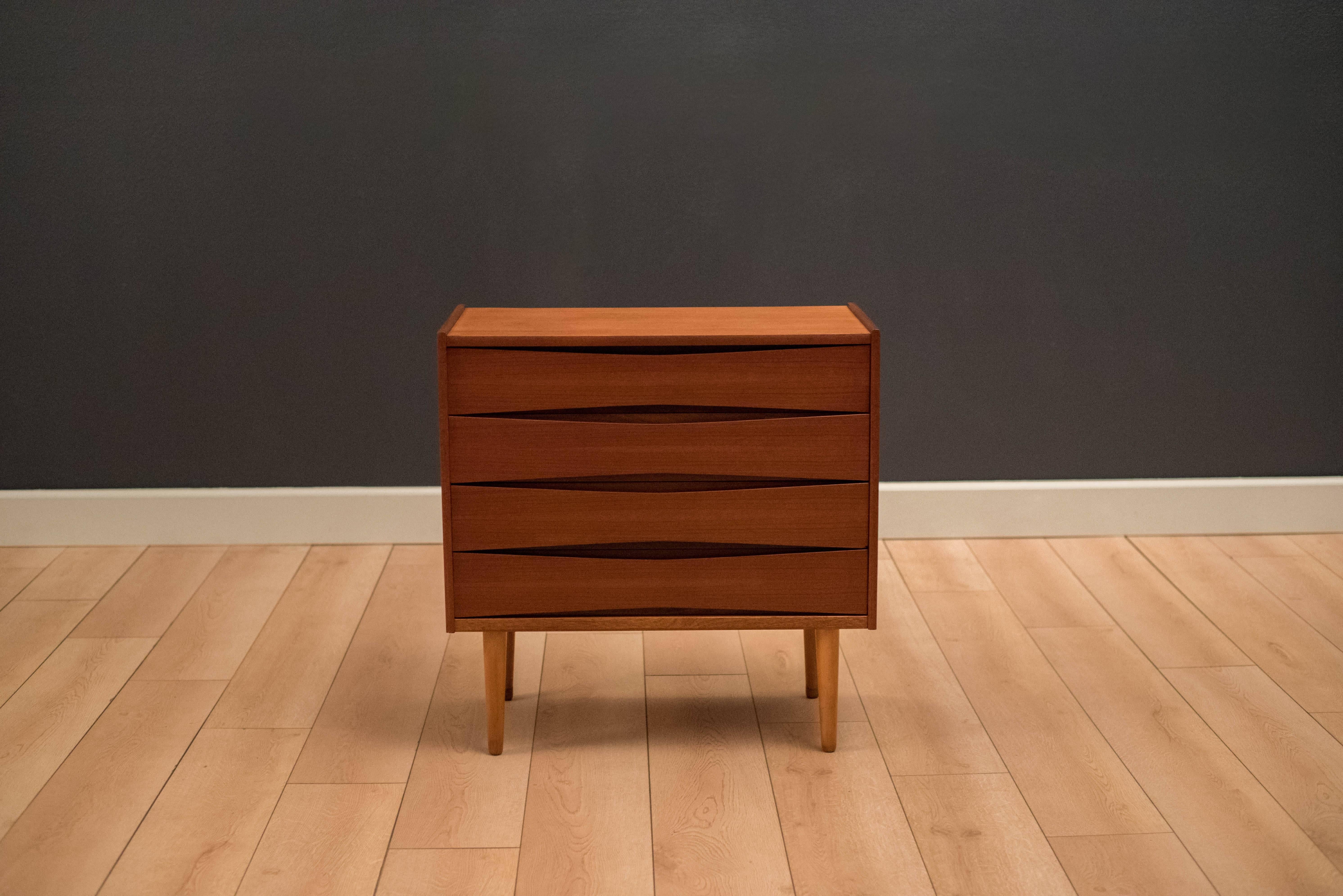 Mid-Century low chest of drawers in teak by Fredrik Kayser for Skeie and Co. This piece includes four drawers with sculpted handles.