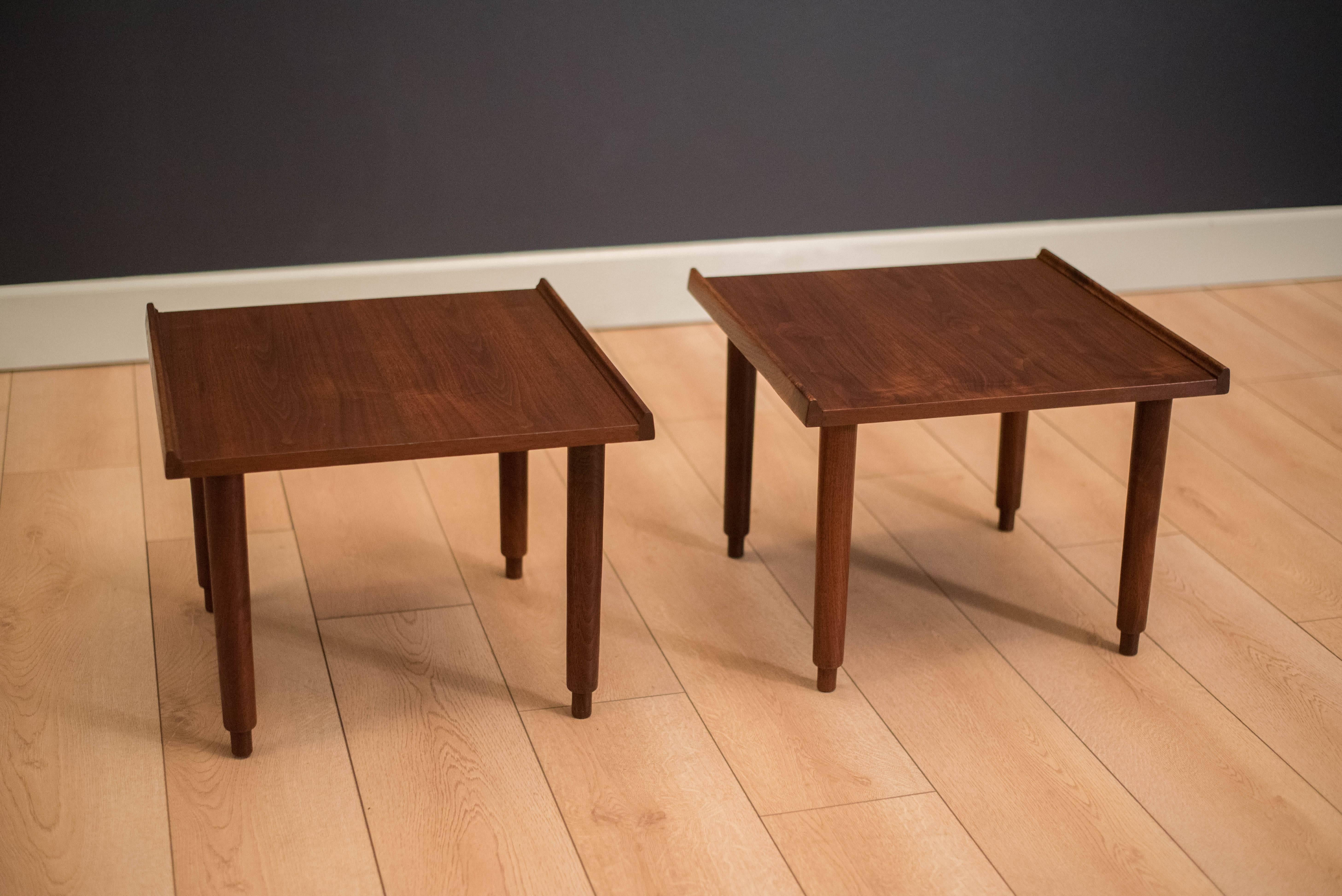 Mid-century California Modern side tables by Charles Pechanec in walnut. This pair features sculpted raised edges and unique legs. Price is for the pair.