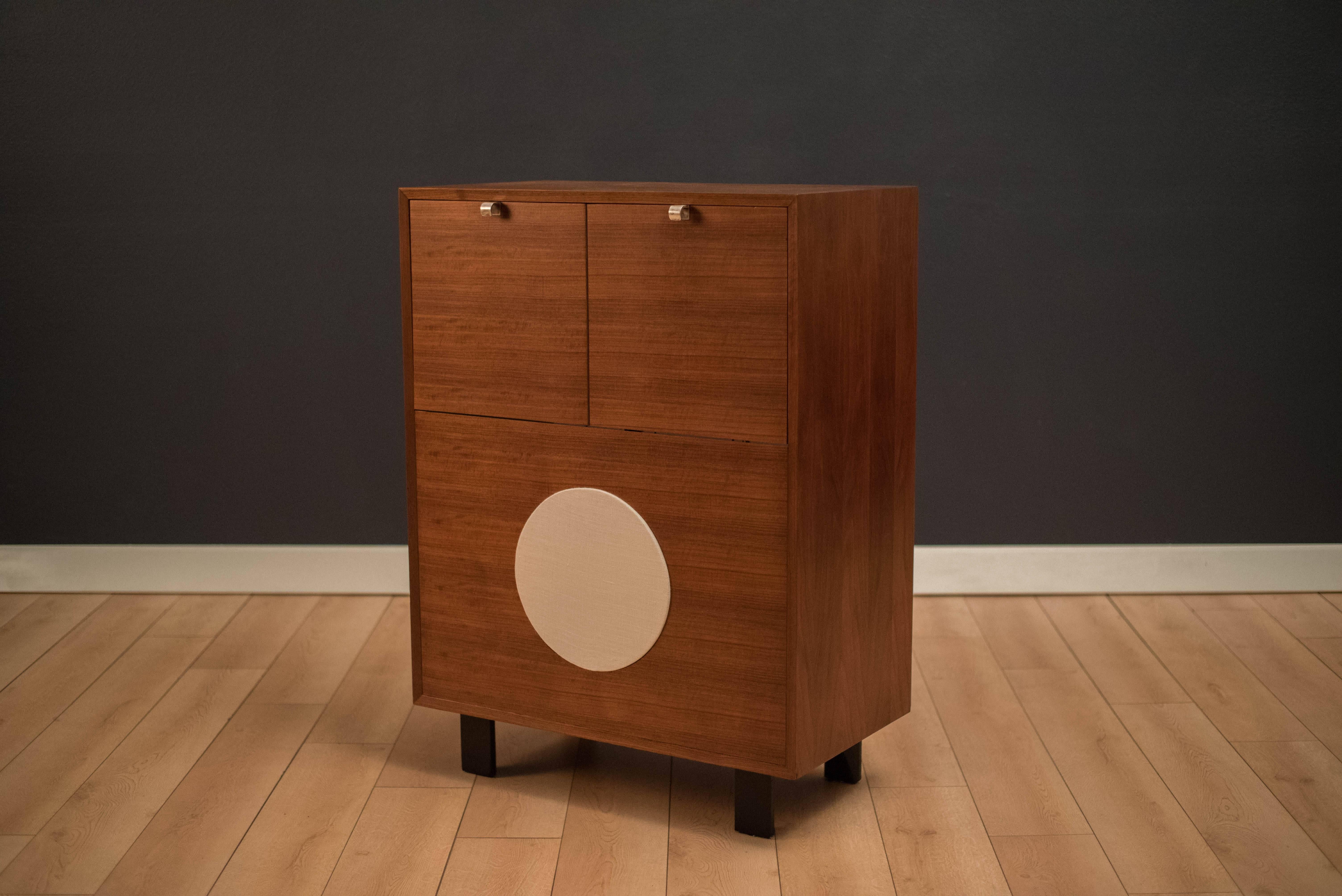 Mid-Century walnut record cabinet designed by George Nelson for Herman Miller. This piece retains the original black lacquered legs and signature aluminum pulls making it an iconic piece to any audio collection. Includes the original record player